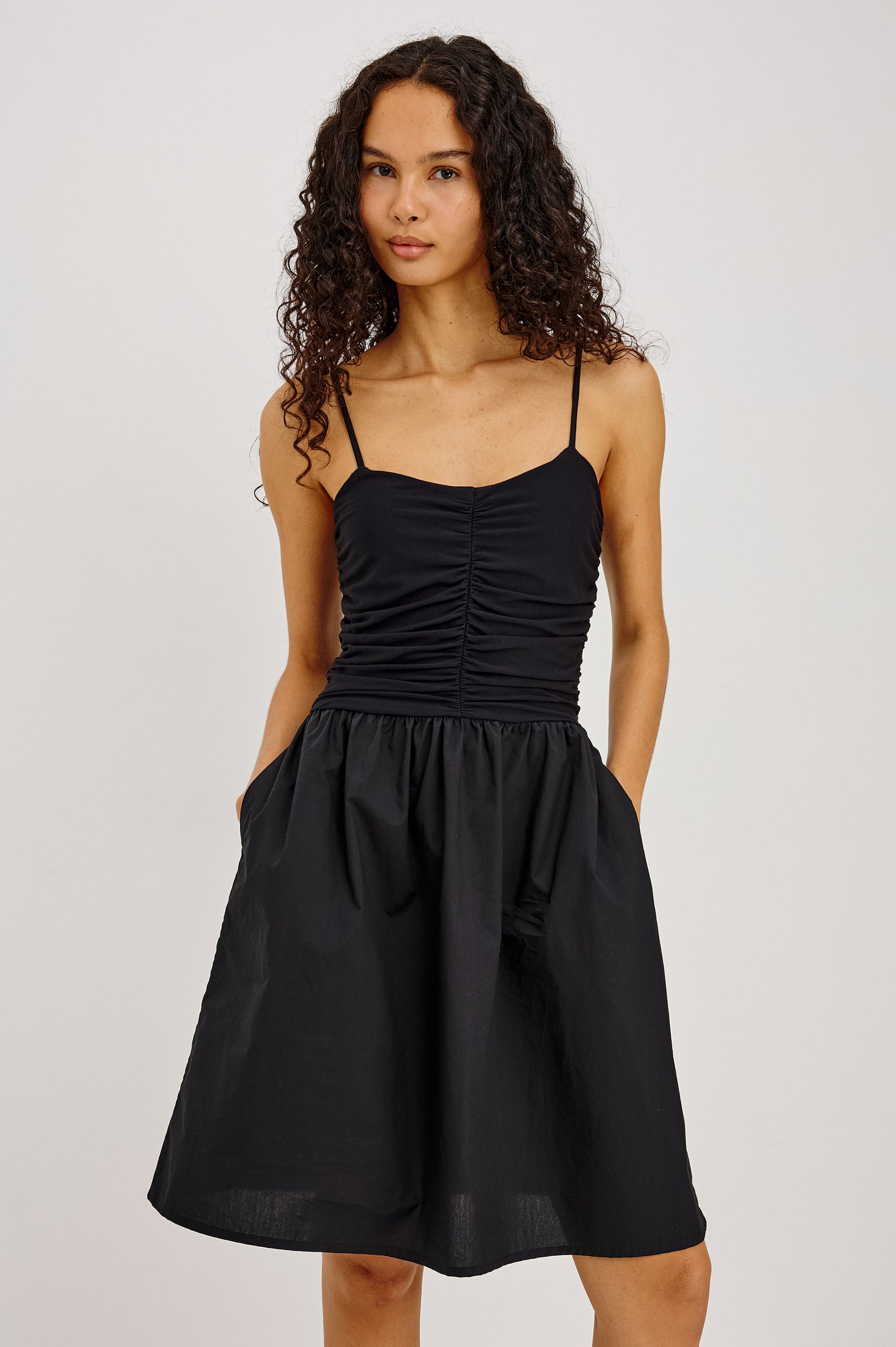 Vienne Mini Dress With Ruched Jersey Fitted Bodice, Full Cotton Poplin Skirt, and Side Pockets in Black Colorway - Upper Body Front View Featured on Model