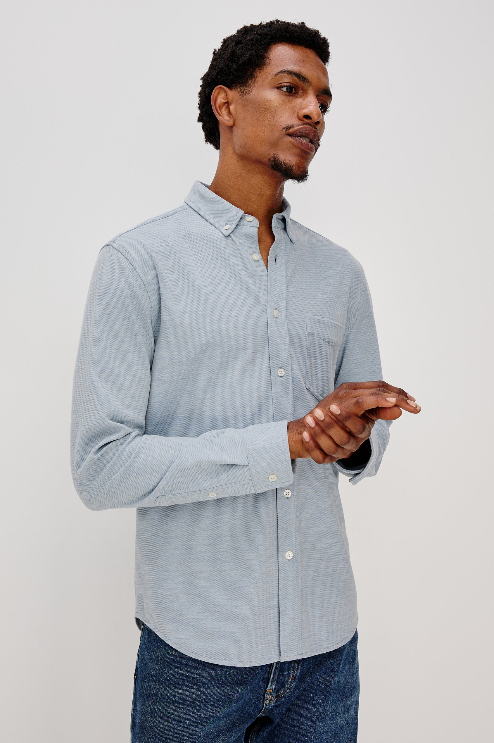Vincent is a collared long sleeve button front shirt with a chest pocket in Blue Oxford colorway. Front view featured on model.