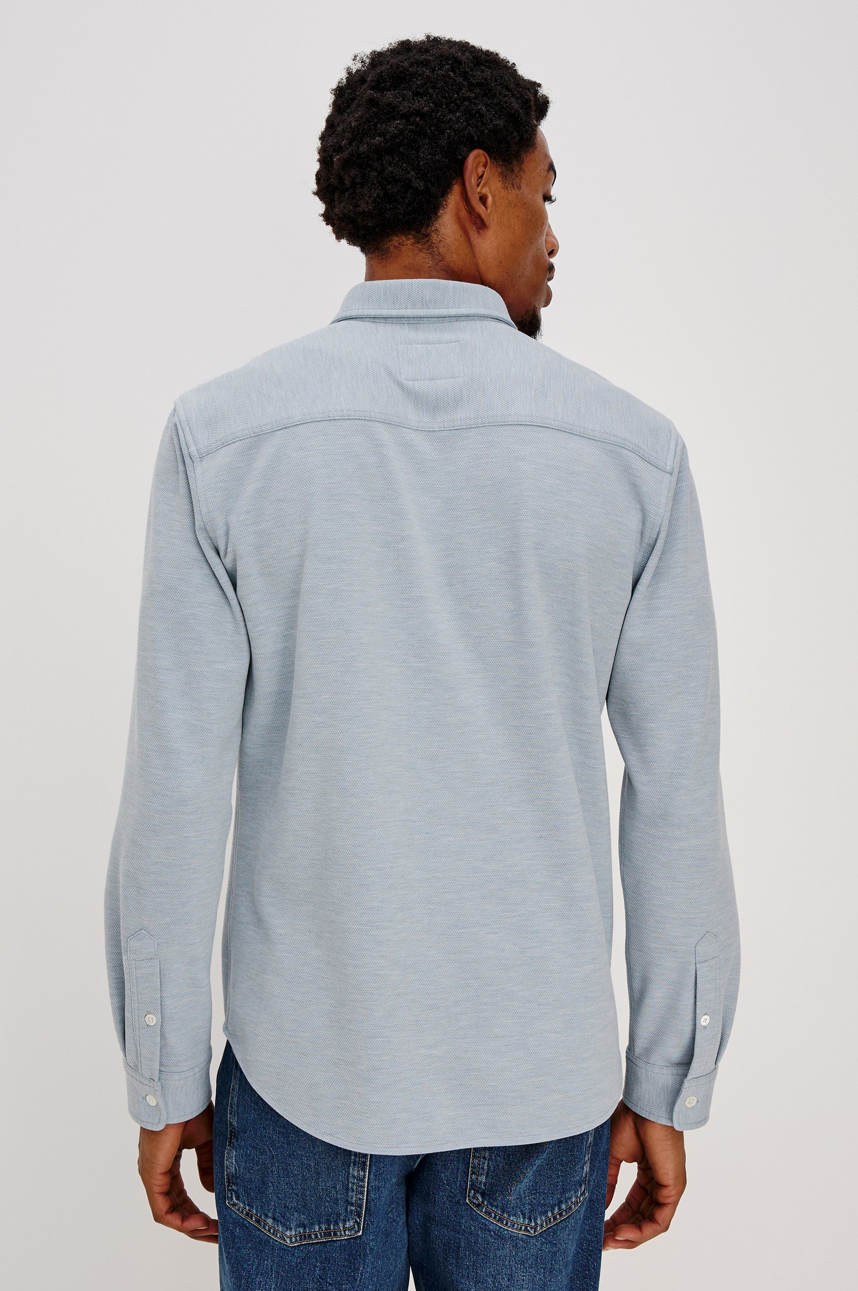 Vincent is a collared long sleeve button front shirt with a chest pocket in Blue Oxford colorway. Back view featured on model.