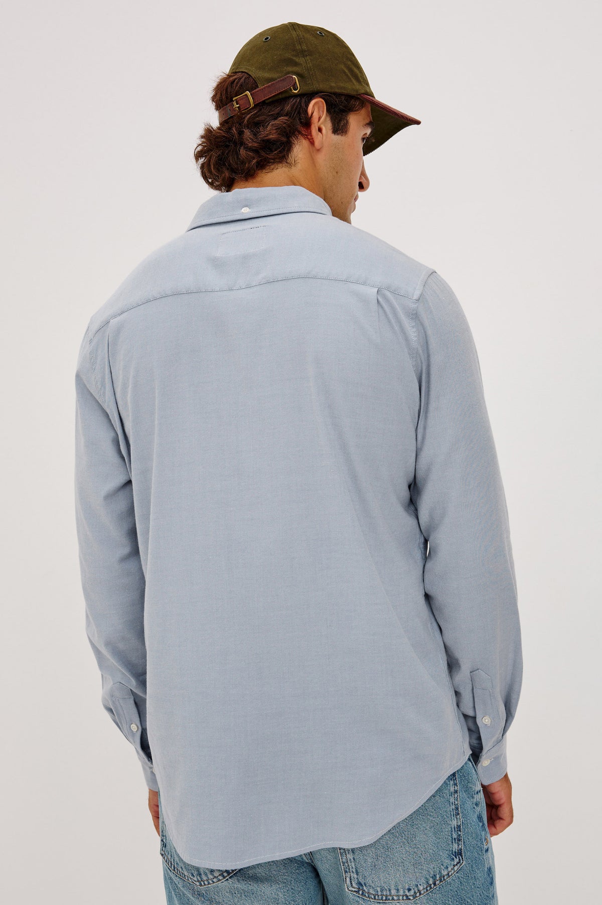 Vincent is a Collared Long Sleeve Button Front Shirt with a Chest Pocket in Blue Oxford Colorway - Upper Body Back View Featured on Model.