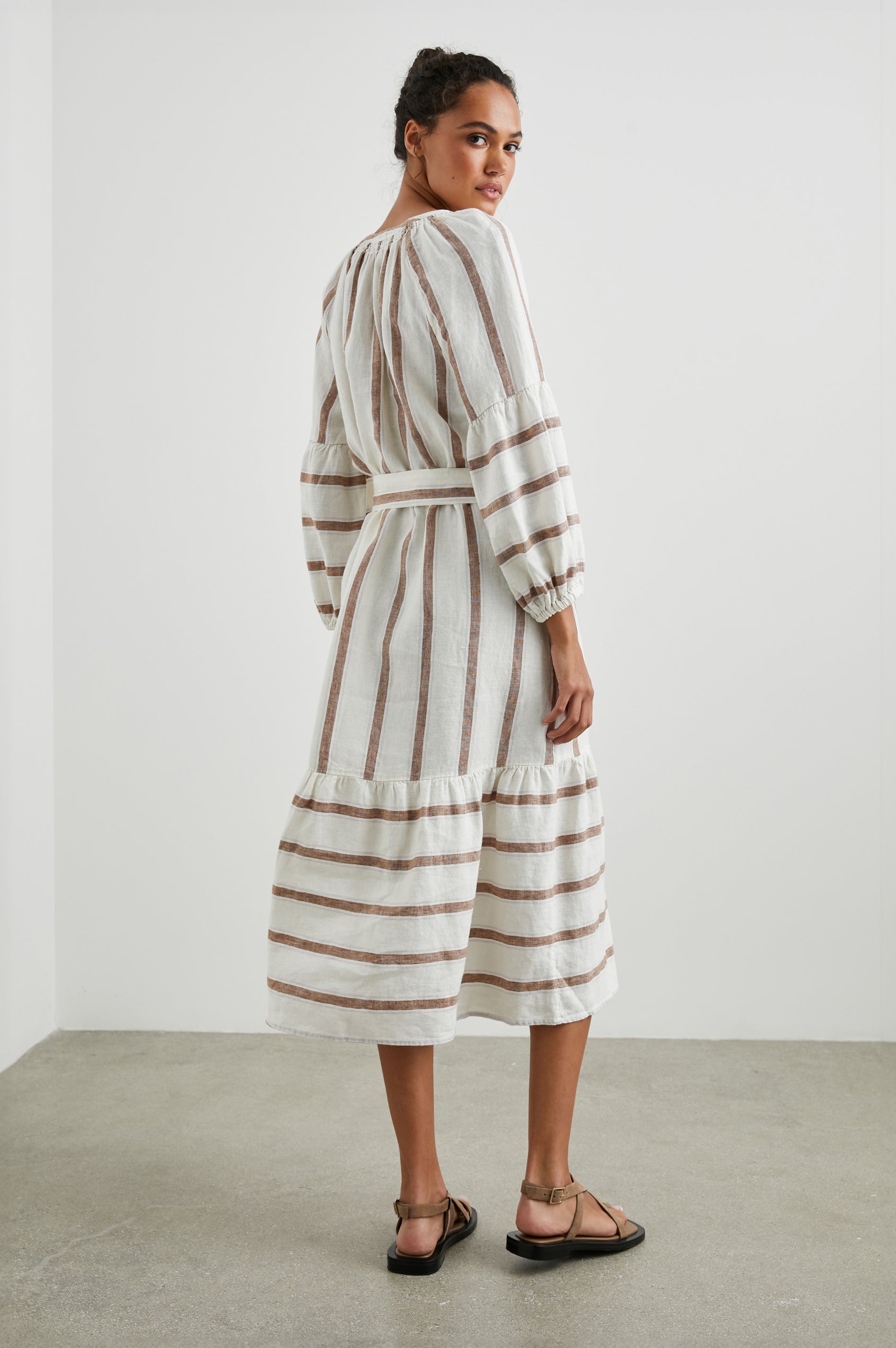 Vittoria Midi Dress with Three-Quarter Sleeves, a V Neck, Light Ruching at the Collar, and a Fabric Tie Belt in Coconut Stripe Colorway, Coconut Vertical Stripes on White with Horizontal Stripes at the Hem - Back Full Body View Featured on Model