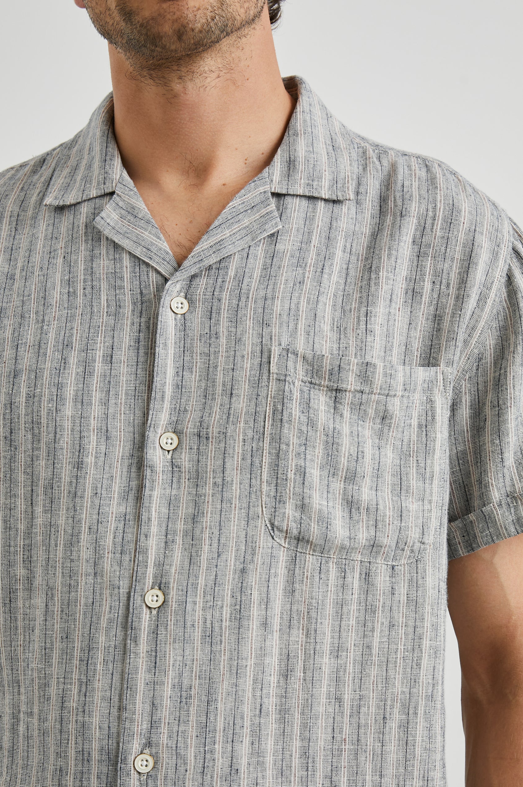 Waimea Short-Sleeve Button Up with a Chest Patch Pocket in Quinoa Navy Stripe Colorway, Thin Vertical White and Navy Stripes on Quinoa - Front View Featured on Model