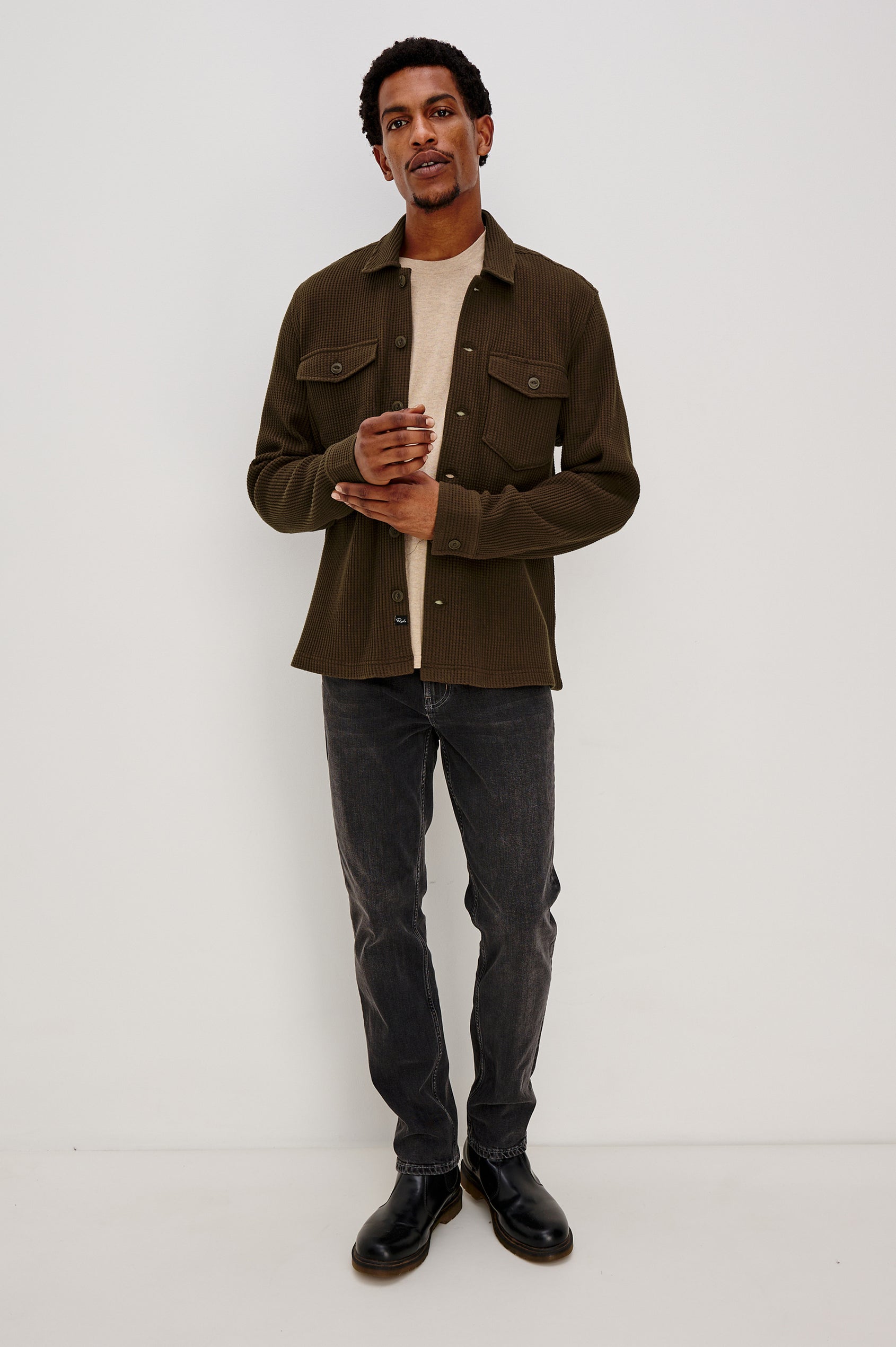 The Wells is a collared button front shirt jacket with contrast brown buttons and two chest pockets in Barley colorway. Front full body view featured on model.