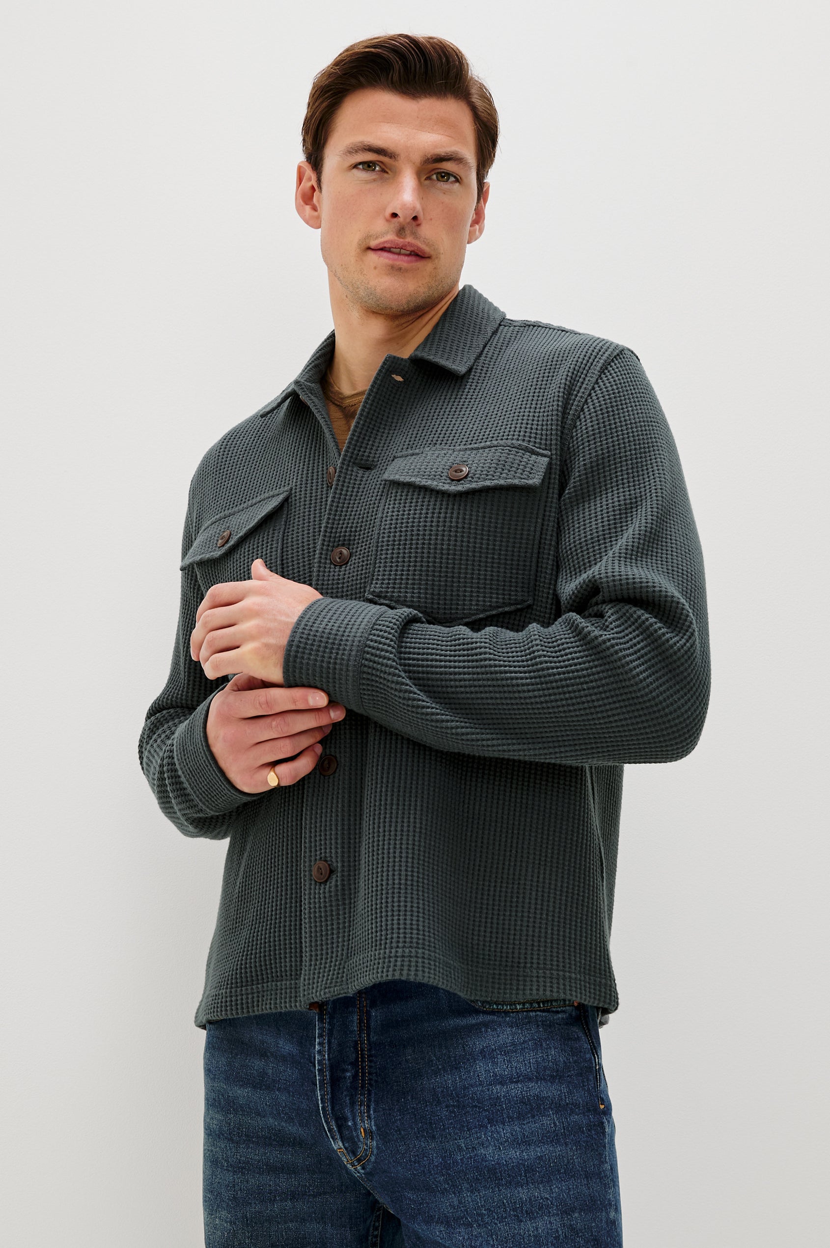 The Wells is a collared button front shirt jacket with contrast brown buttons and two chest pockets in Ink colorway. Front  view featured on model.