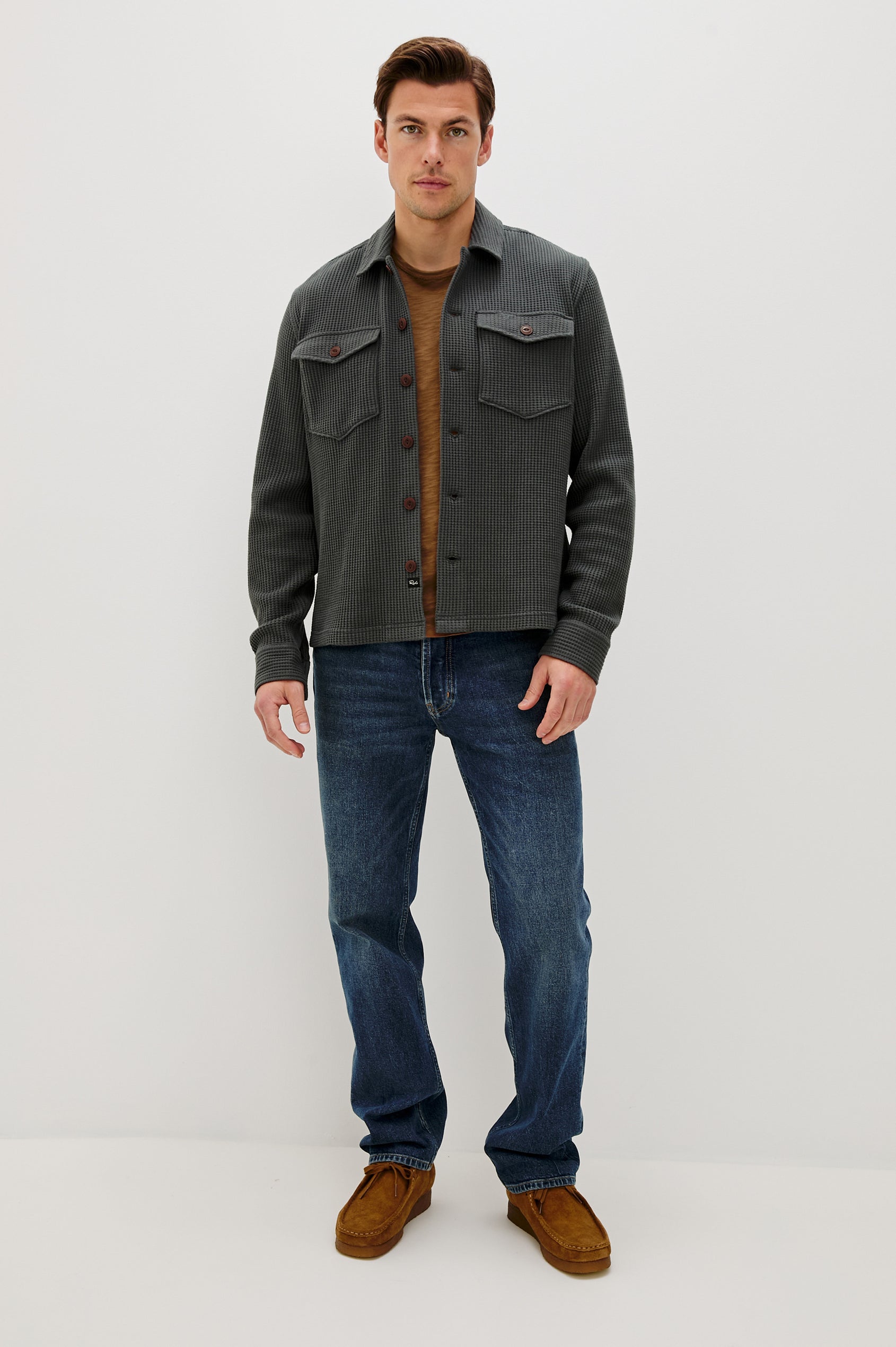 The Wells is a collared button front shirt jacket with contrast brown buttons and two chest pockets in Ink colorway. Front full body view featured on model.