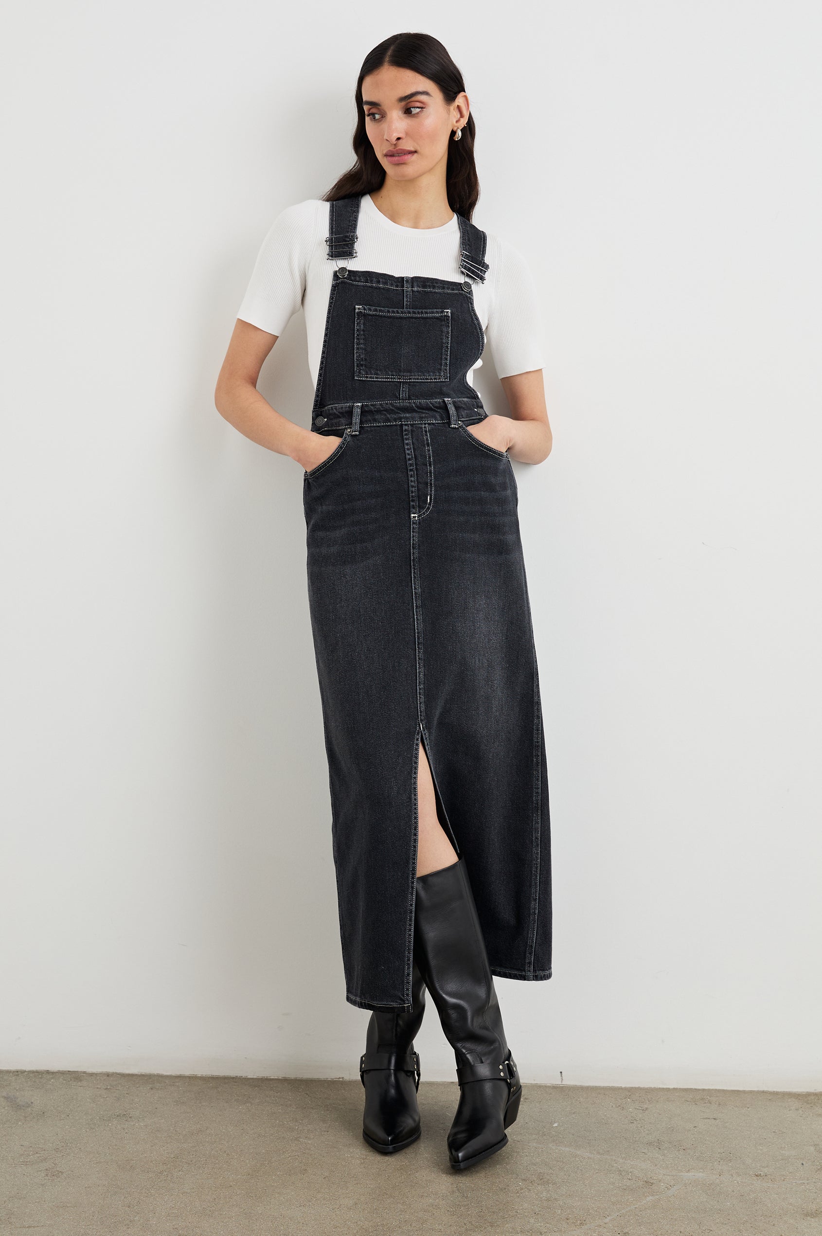 Westlake Midi Denim Dress with an Overalls-Style Bodice, Two Front Pockets, a Bib Chest Patch Pocket, Two Back Patch Pockets, Belt Loops and a Center Slit in Black Sand Colorway - Front Full Body View Featured on Model