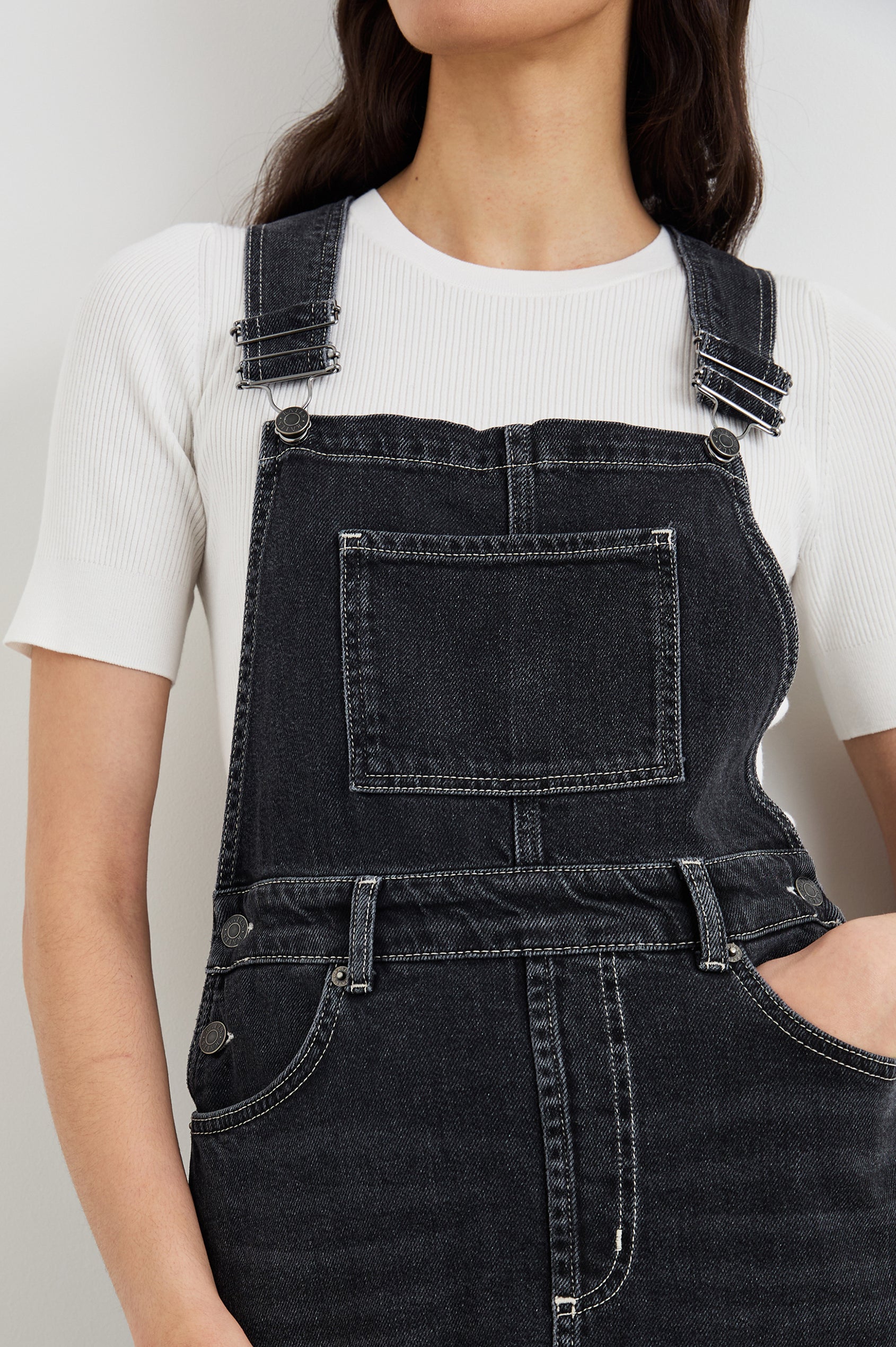 Westlake Midi Denim Dress with an Overalls-Style Bodice, Two Front Pockets, a Bib Chest Patch Pocket, Two Back Patch Pockets, Belt Loops and a Center Slit in Black Sand Colorway - Front View Featured on Model