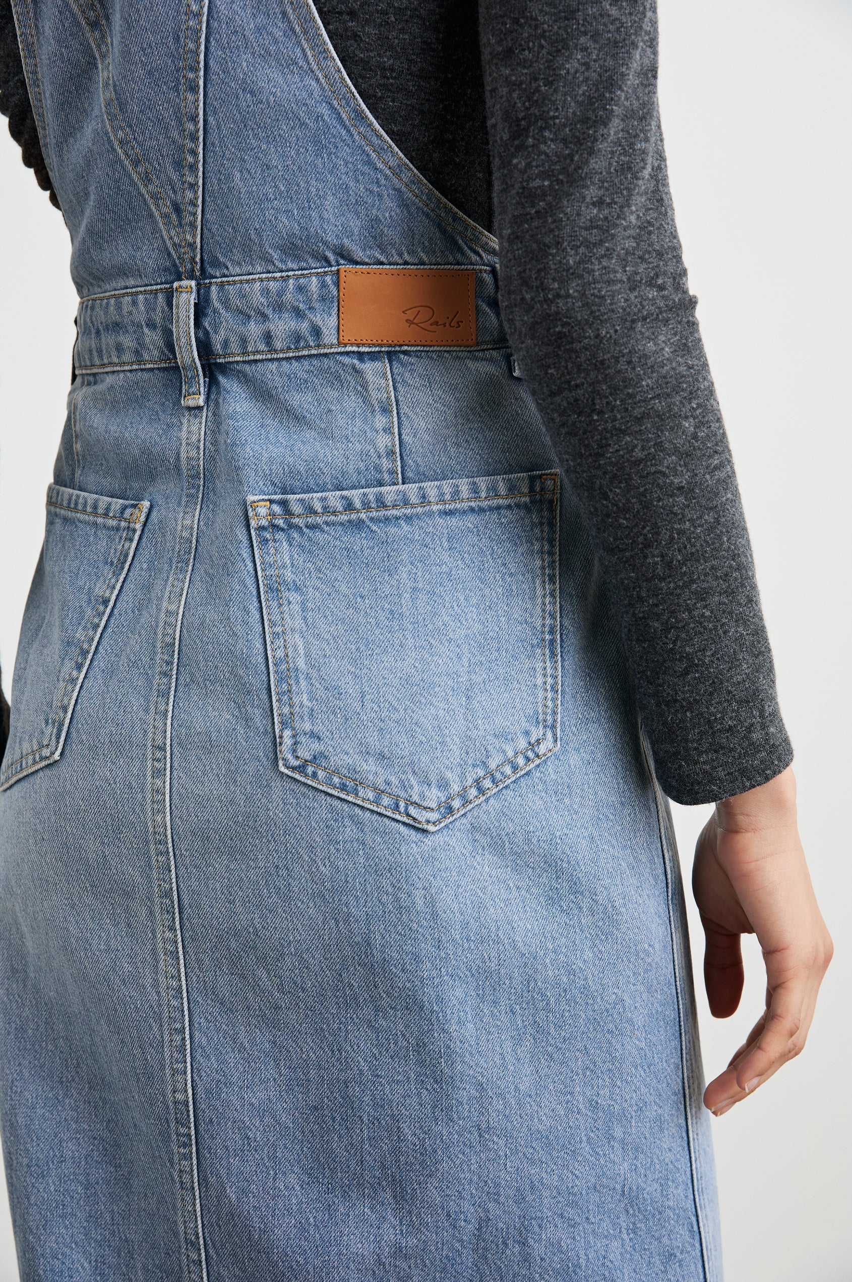 Westlake Midi Denim Dress with an Overalls-Style Bodice, Two Front Pockets, a Bib Chest Patch Pocket, Two Back Patch Pockets, Belt Loops and a Center Slit in South Coast Colorway - Back View Featured on Model
