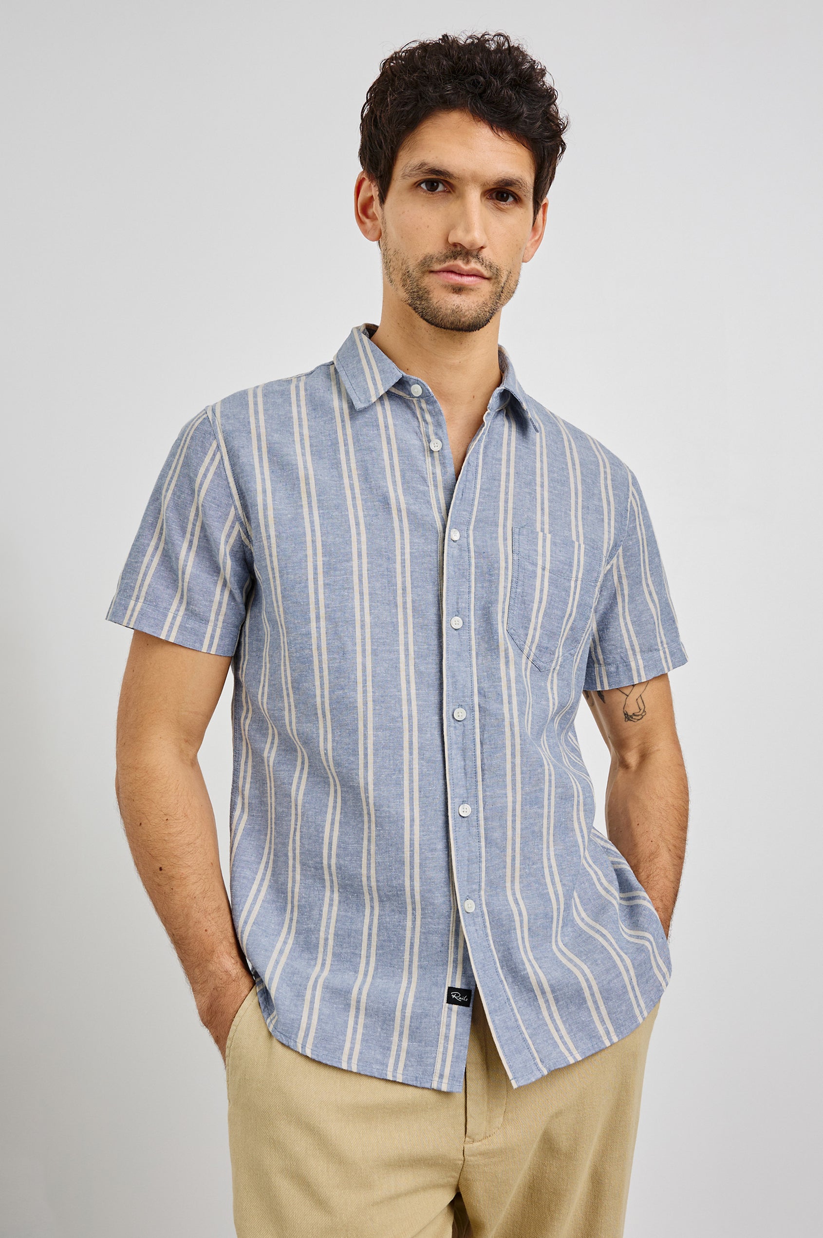 Wilder Collared Button Front Shirt with Short Sleeves and a Chest Pocket in Chambray Butter Colorway. Front View Shown on Model.