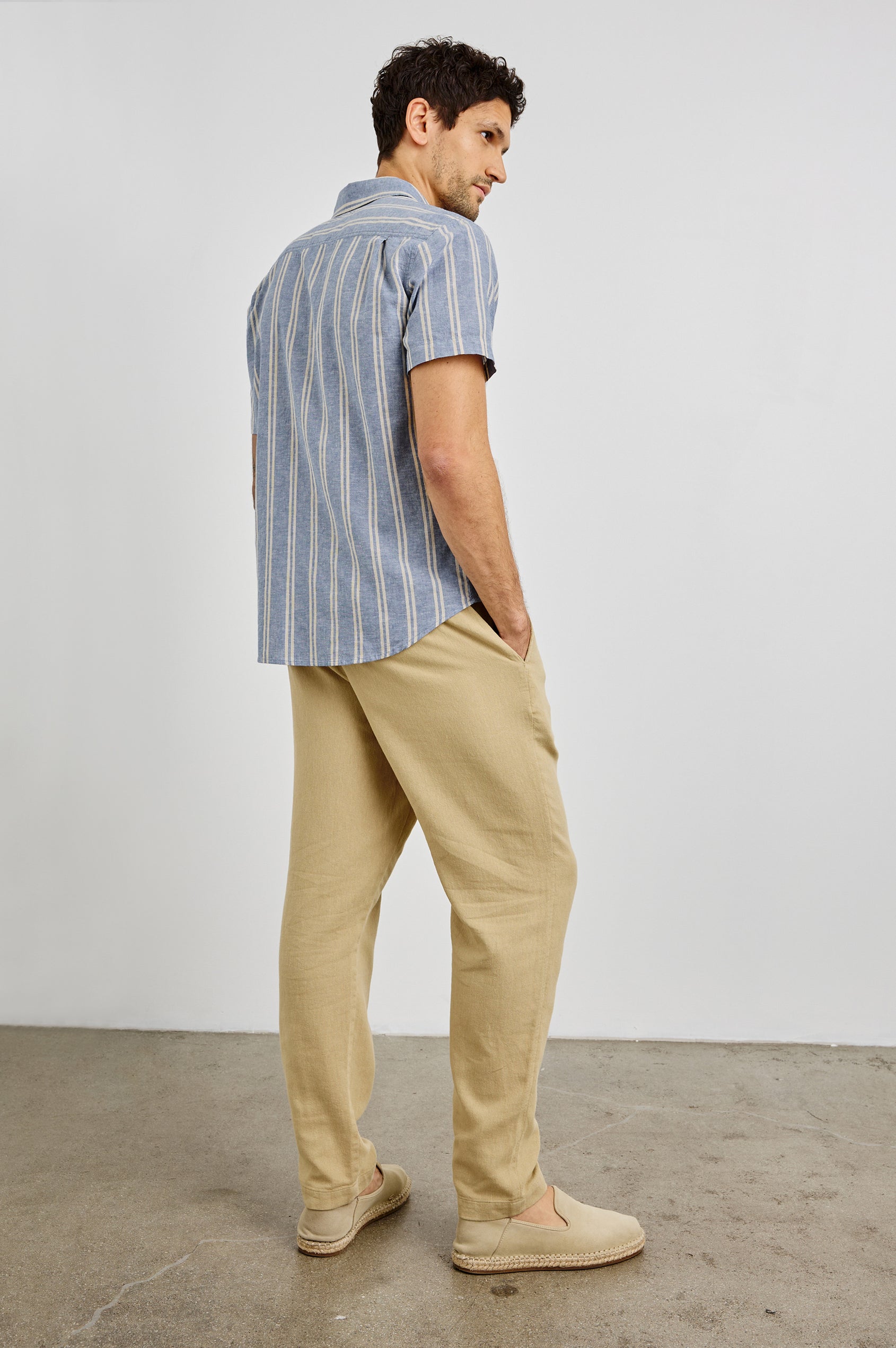 Wilder Collared Button Front Shirt with Short Sleeves and a Chest Pocket in Chambray Butter Colorway. Back View Shown on Model.