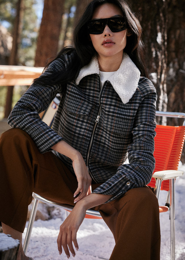 EDITORIAL CLOSE UP OF MODEL SITTING WEARING CHEYENNE JACKET IN ONYX TAUPE PINK AND HARLOW PANT IN HENNA
