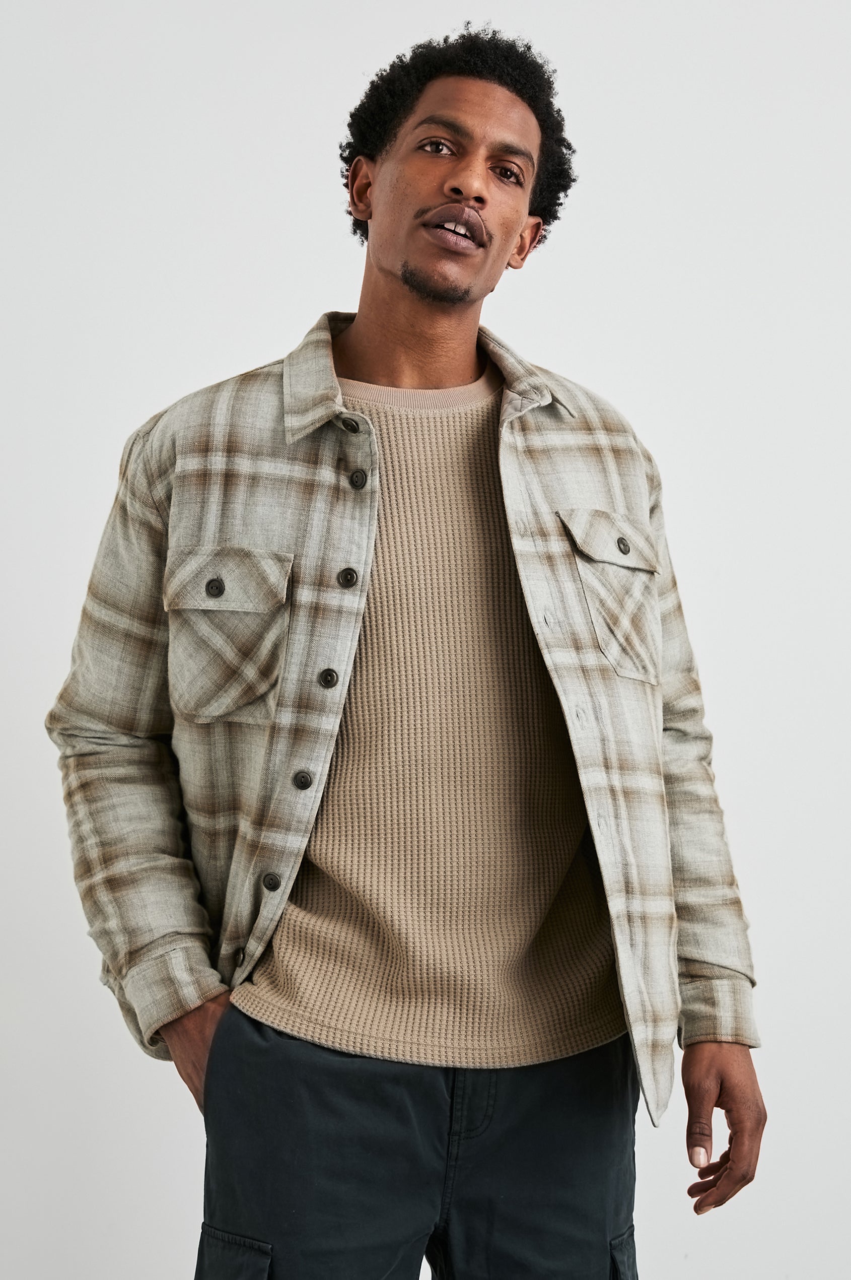 Worthing Jacket with Button Closure and two Chest Button Flap Pockets in Matchbook Moth Colorway, a Brown and Cream Plaid - Front View Featured on Model
