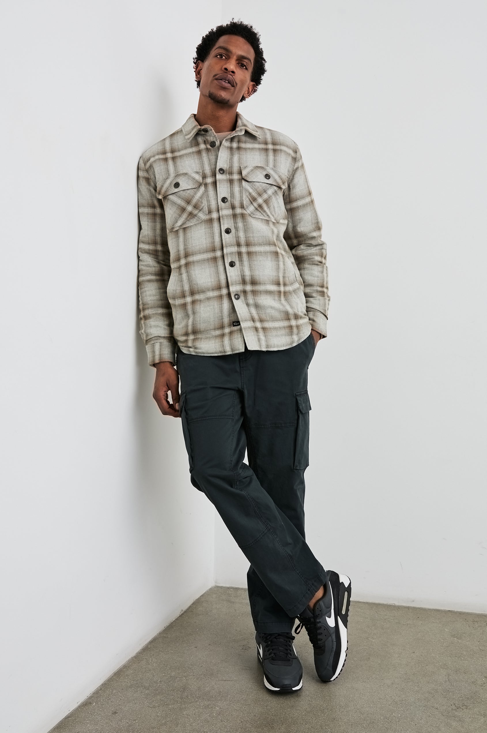 Worthing Jacket with Button Closure and two Chest Button Flap Pockets in Matchbook Moth Colorway, a Brown and Cream Plaid - Front Full Body View Featured on Model