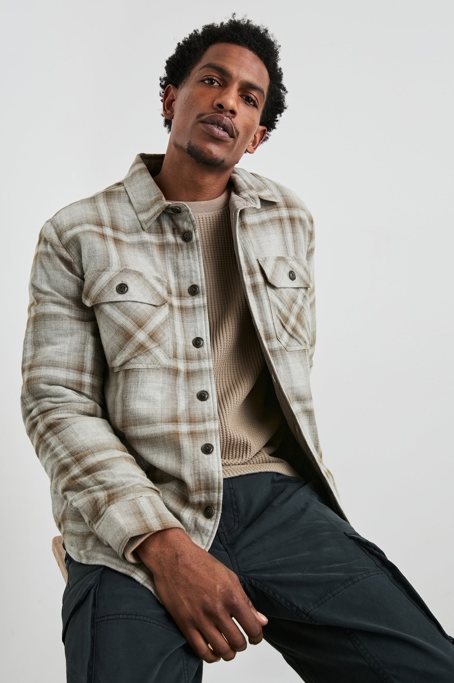 Worthing Jacket with Button Closure and two Chest Button Flap Pockets in Matchbook Moth Colorway, a Brown and Cream Plaid - Front View Featured on Model