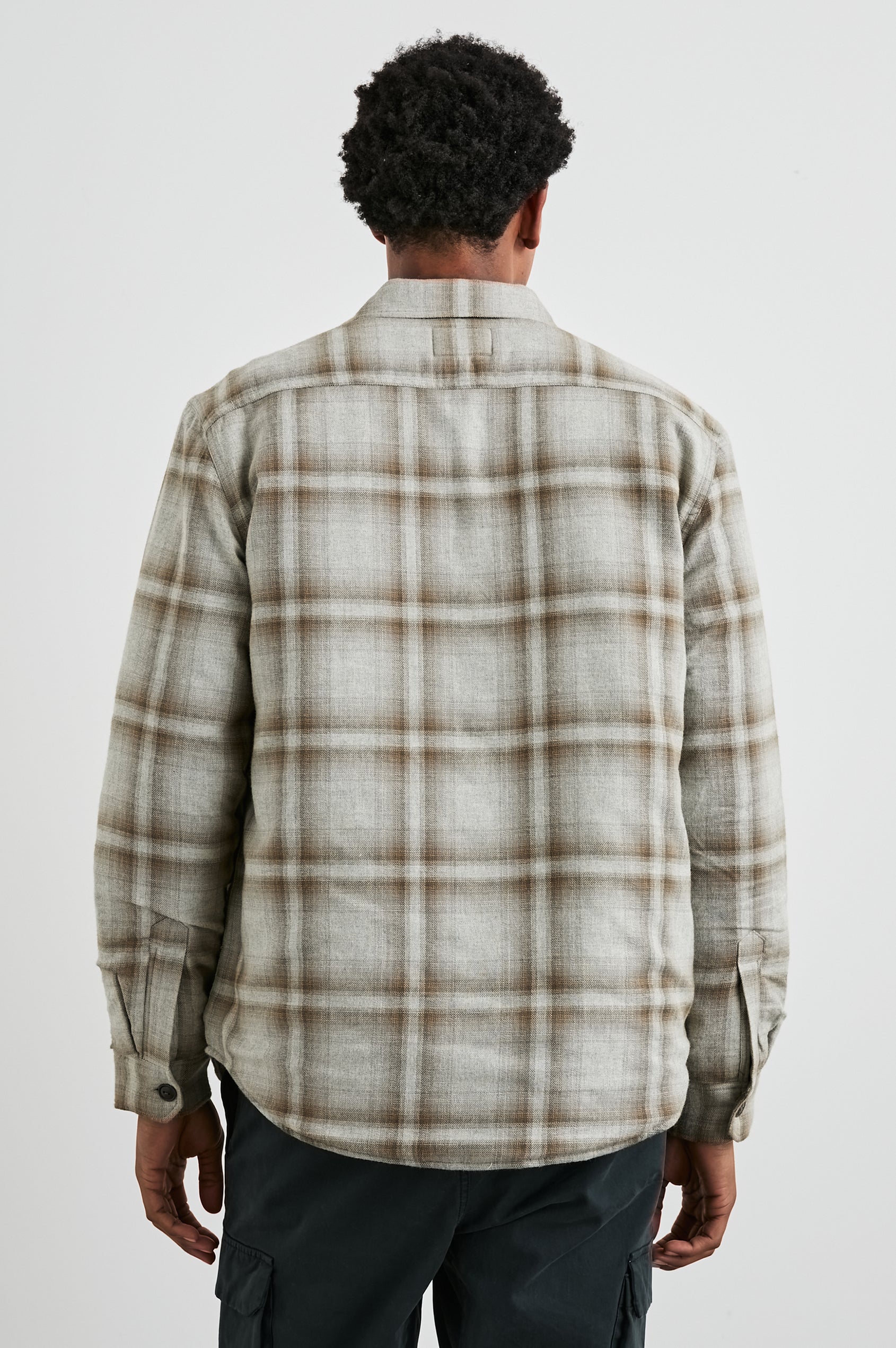 Worthing Jacket with Button Closure and two Chest Button Flap Pockets in Matchbook Moth Colorway, a Brown and Cream Plaid - Back View Featured on Model