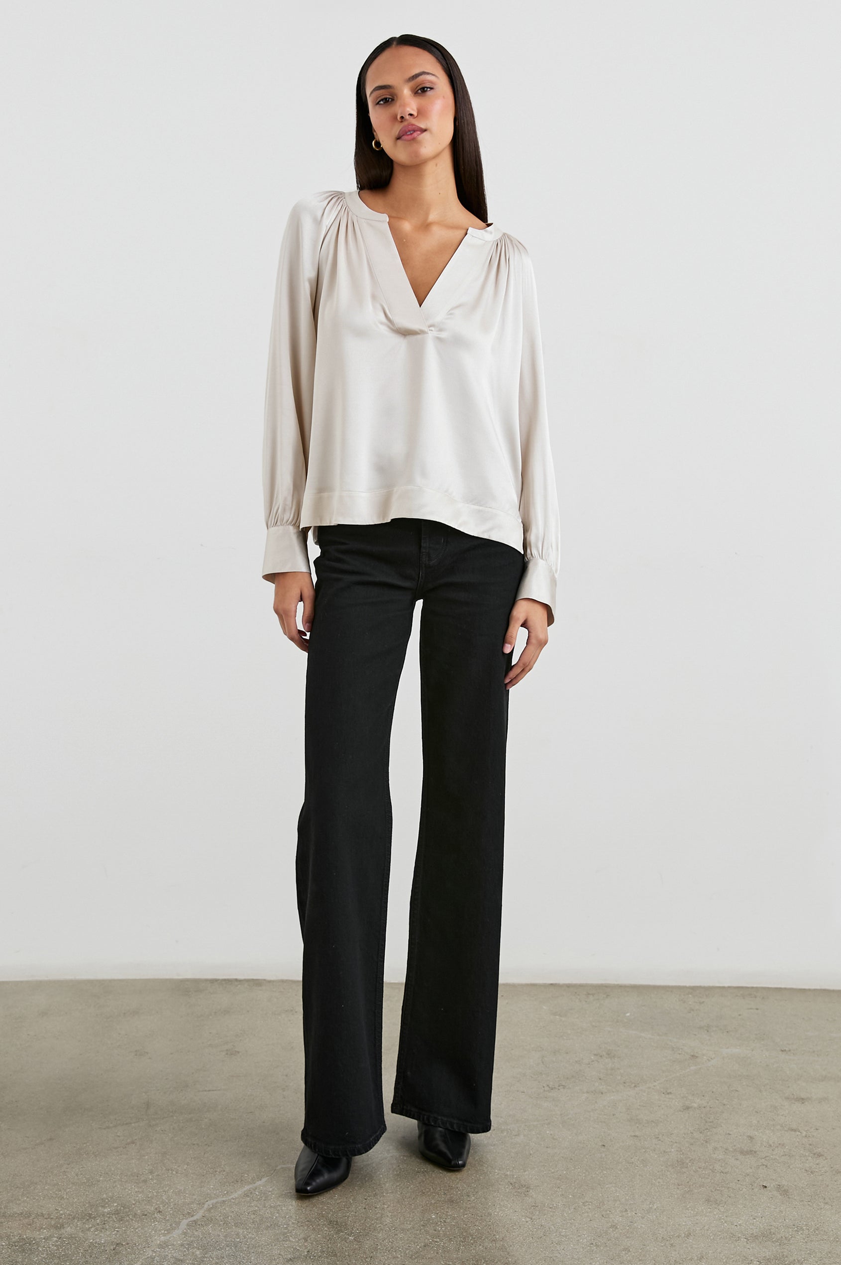 Wynna Long-Sleeve Top with a Deep V Neck and Ruching above the Cuffs and at the Neckline in Ivory Colorway - Front View Featured on Model