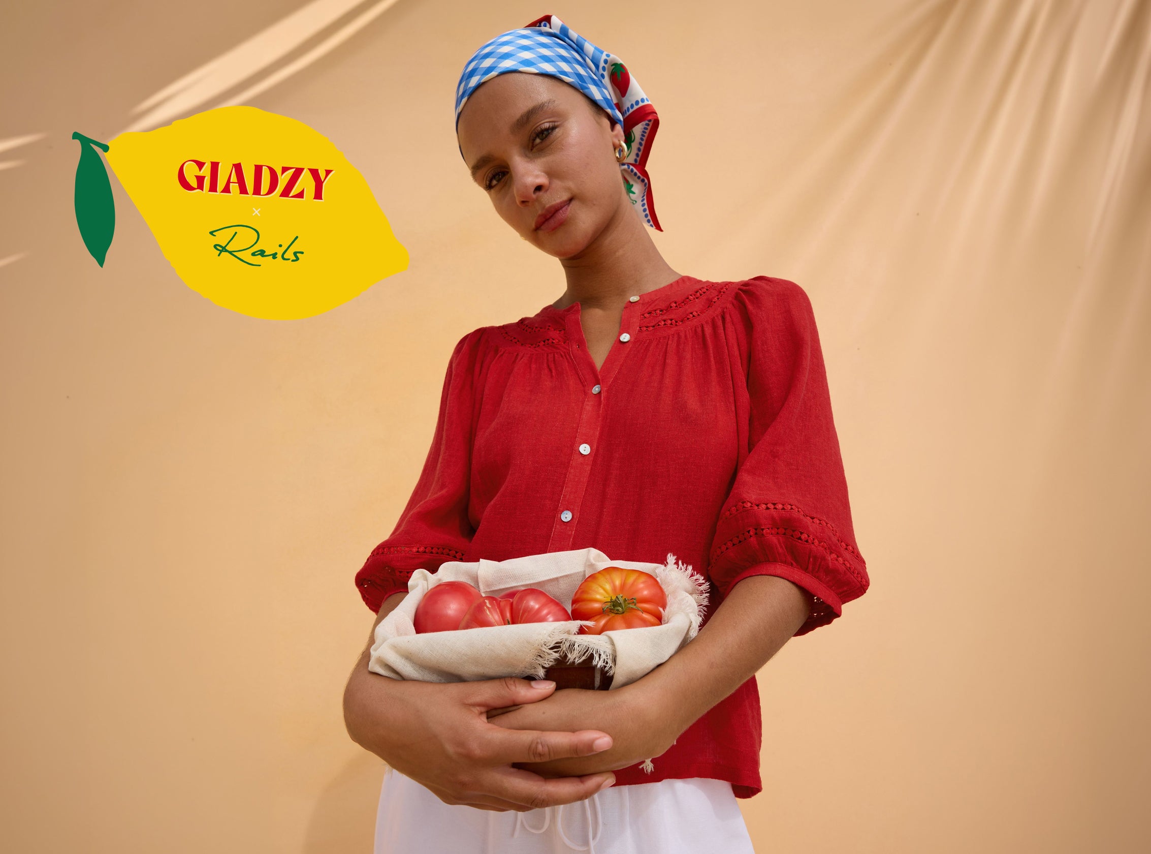 Woman wearing a red top with a gingham print head scarf while holding tomatoes