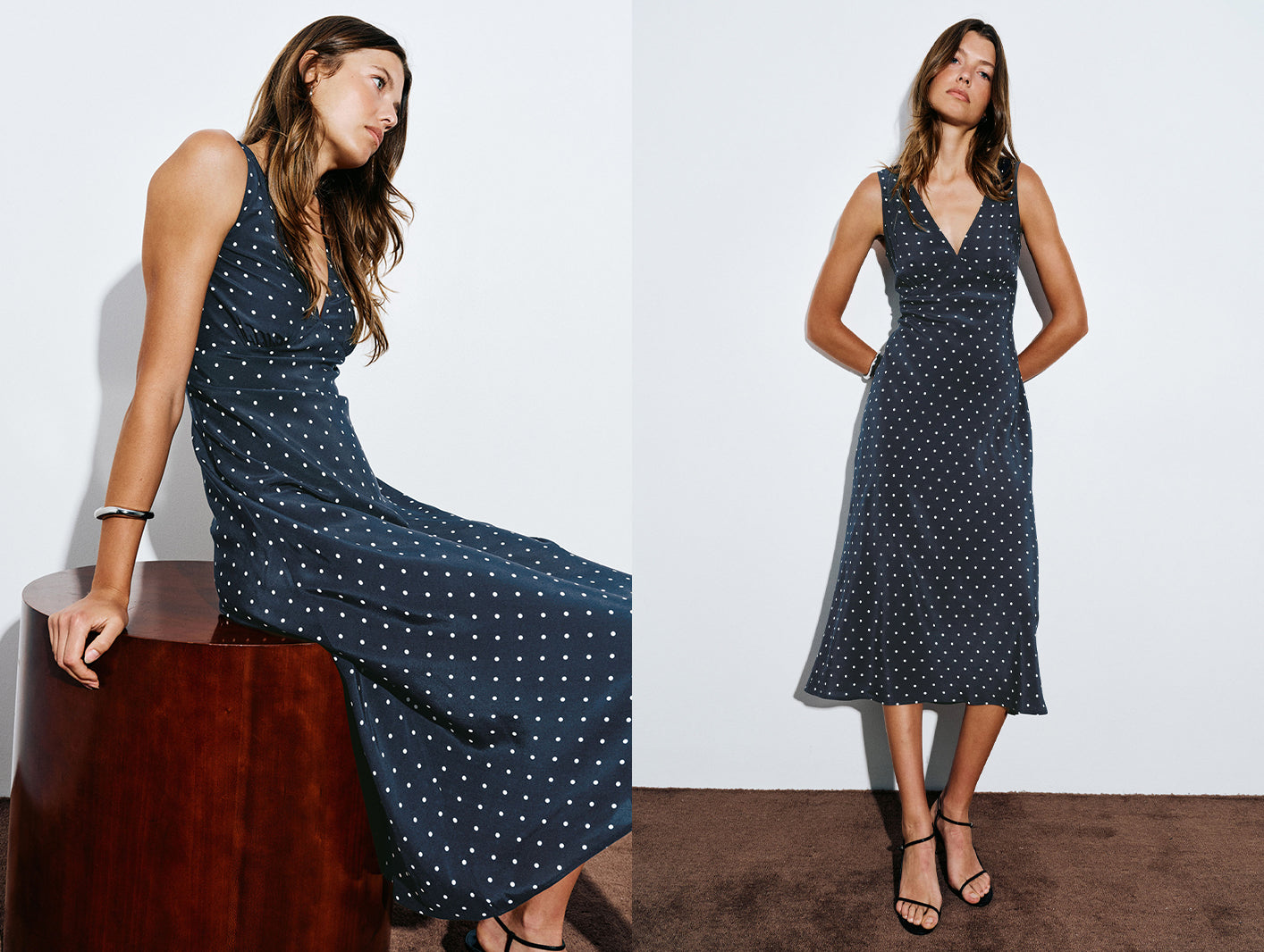 A sleeveless midi dress with a dark navy blue base and small white polka dots, shown on a model in two poses against a white studio background.