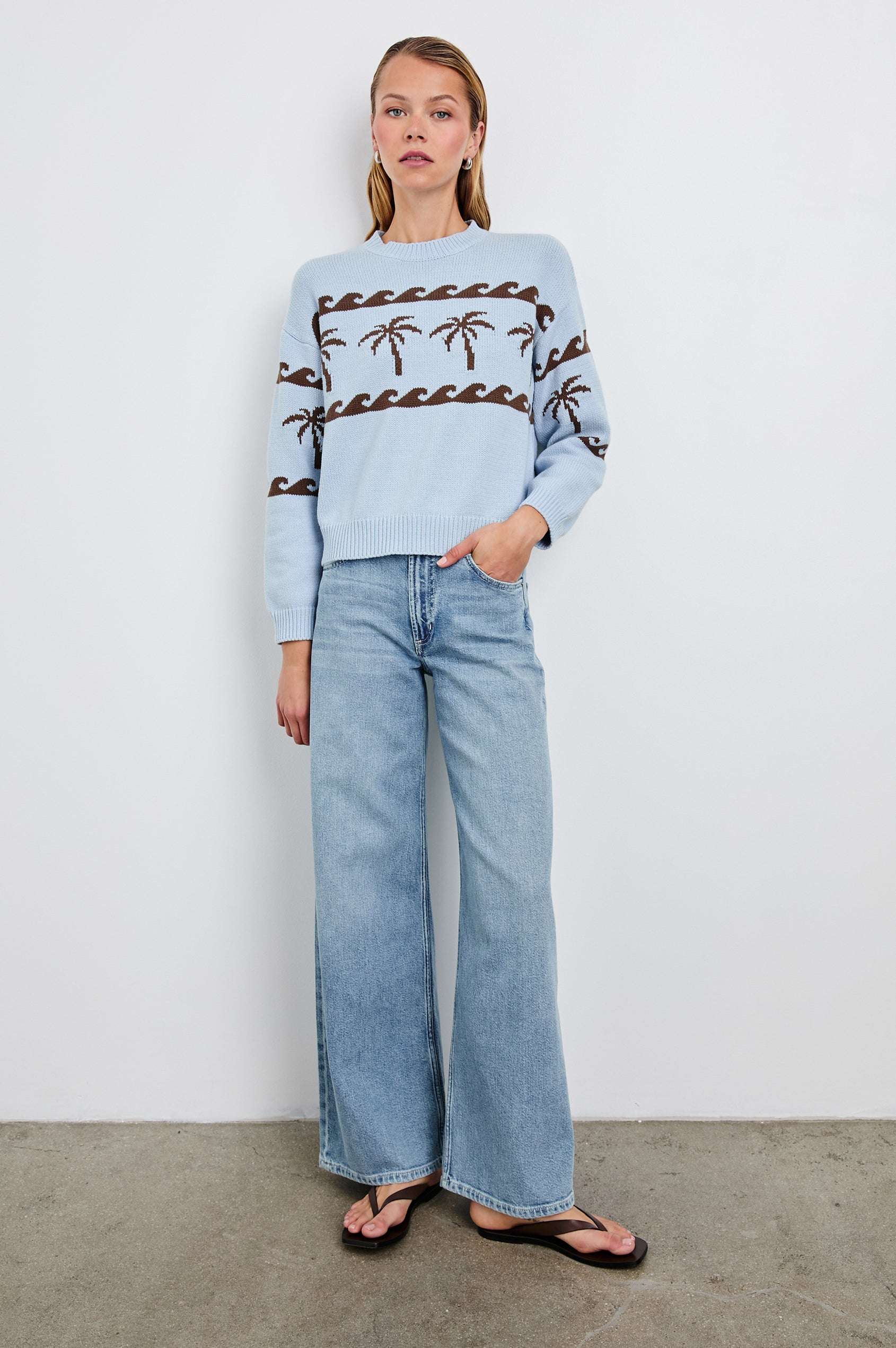 Zoey Long-Sleeve Sweater with Crewneck and Ribbed Trims in Palm Stripe Colorway, a row of brown palm trees bordered by waves on blue  - Front Full Body View Featured on Model