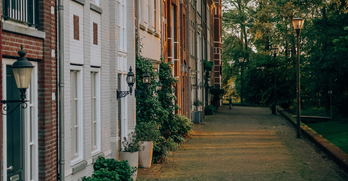 A LONDON SIDE WALK ALONG A ROW OF TOWNHOMES SHOWING STREET LIGHTS AND TREES