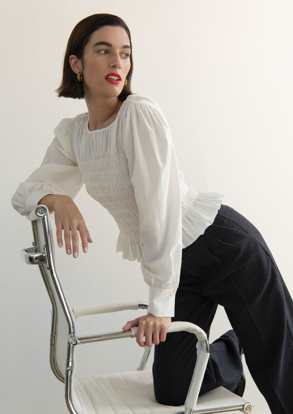 EDITORIAL SIDE SHOT OF MODEL WEARING TABI TOP IN WHITE AND MARNIE PANT IN MIDNIGHT BROWN MINI CHECK