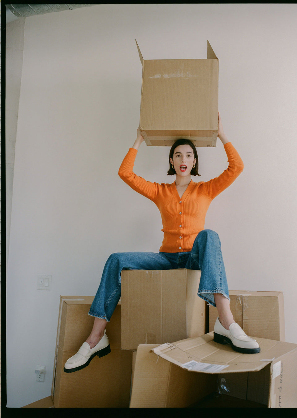 EDITORIAL IMAGE OF MODEL WEARING BEAU CARDIGAN IN TANGERINE AND SPEEDWAY 90S BOYFRIEND JEAN IN SLATE SKY