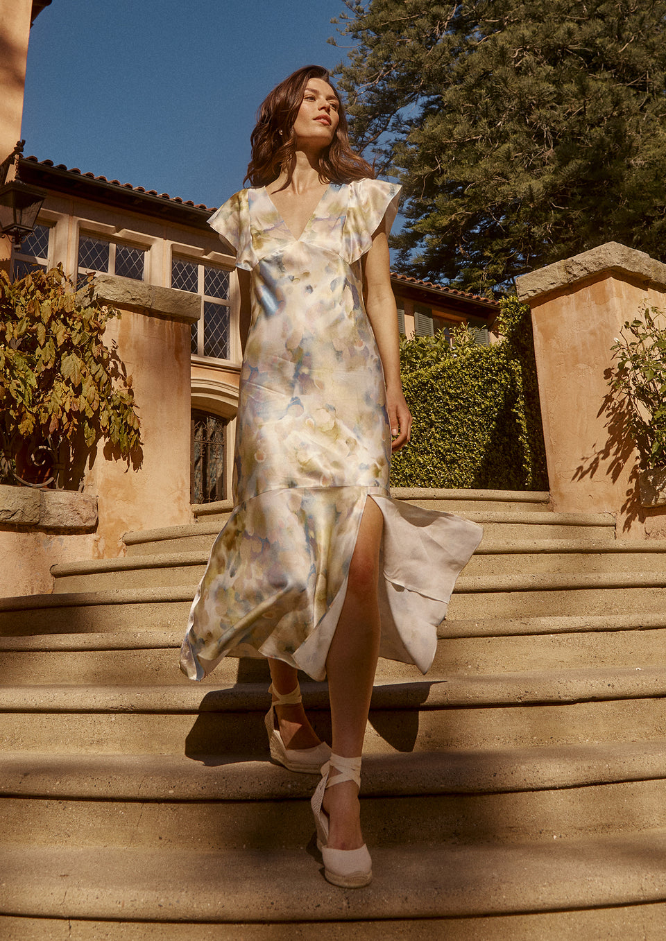FRONT FULL BODY EDITORIAL IMAGE OF MODEL WALKING DOWN STAIRS WEARING DINA DRESS