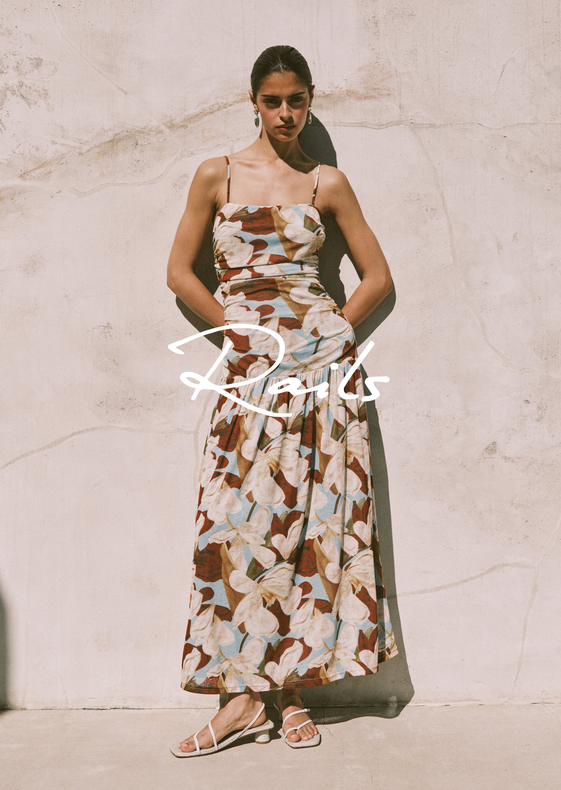 Woman wearing a floral dress with 'Rails' branding against a light background