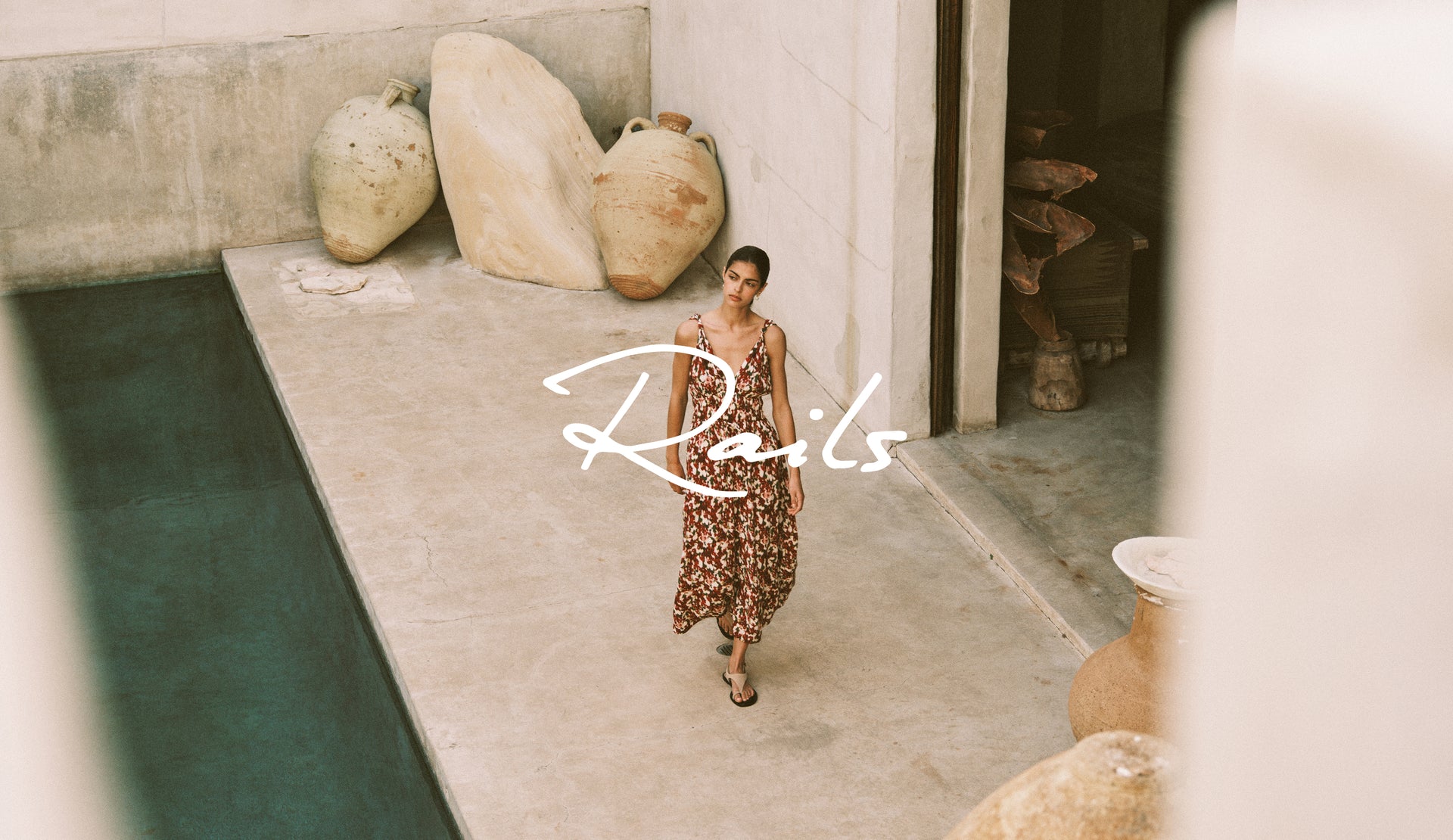 Woman walking by a pool with 'Rails' logo overlay