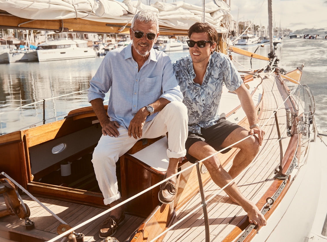 EDITORIAL IMAGE OF TWO MODELS ON A SAIL BOAT. FIRST MODEL IS WEARING FAIRFAX SHIRT. SECOND MODEL IS WEARING CARSON SHIRT.