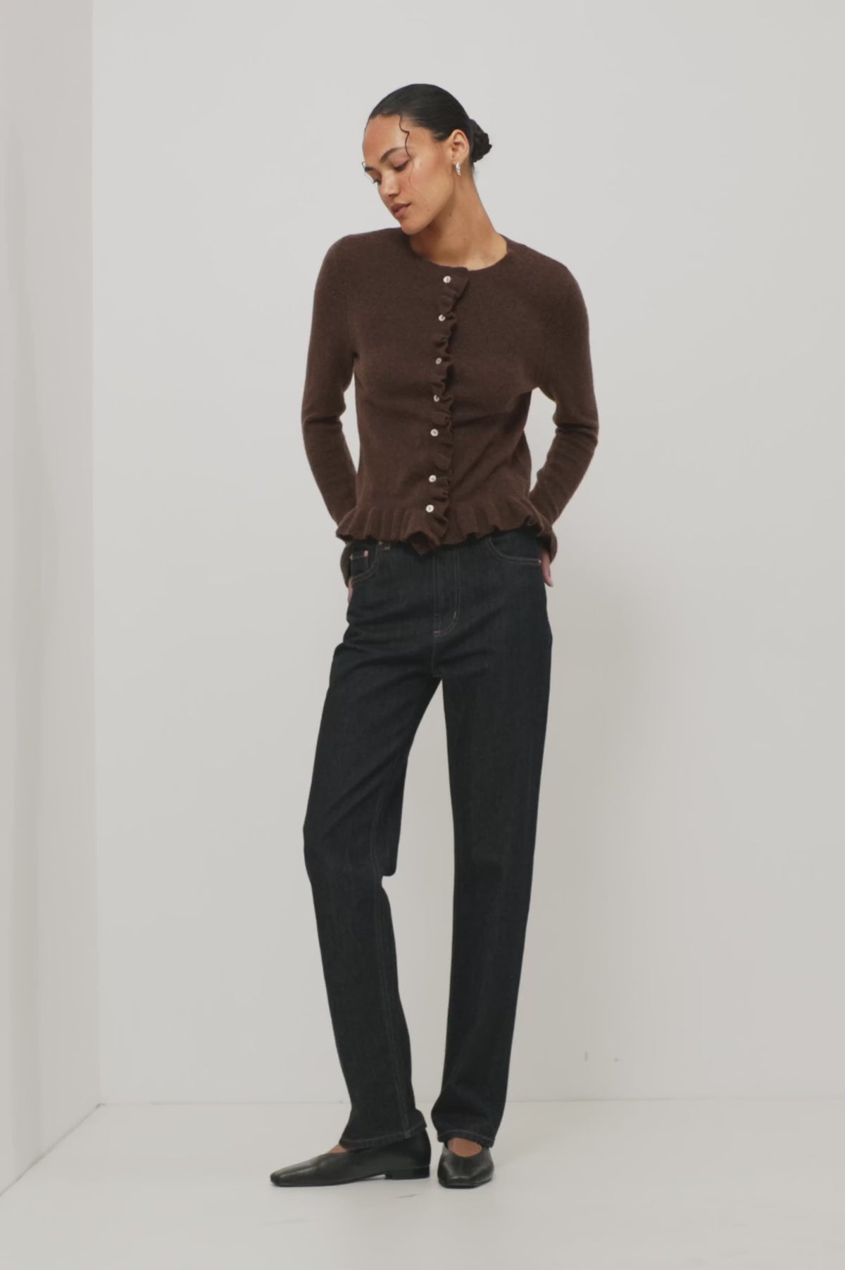 Mandy Sweater in Cashmere-Cotton-Wool Blend Knit Front Buttons, Long Sleeves, Classic Slightly Cropped Fit, and Ribbed Ruffle Trim in Chocolate Colorway - Full Body View Featured on Model Moving (Video).