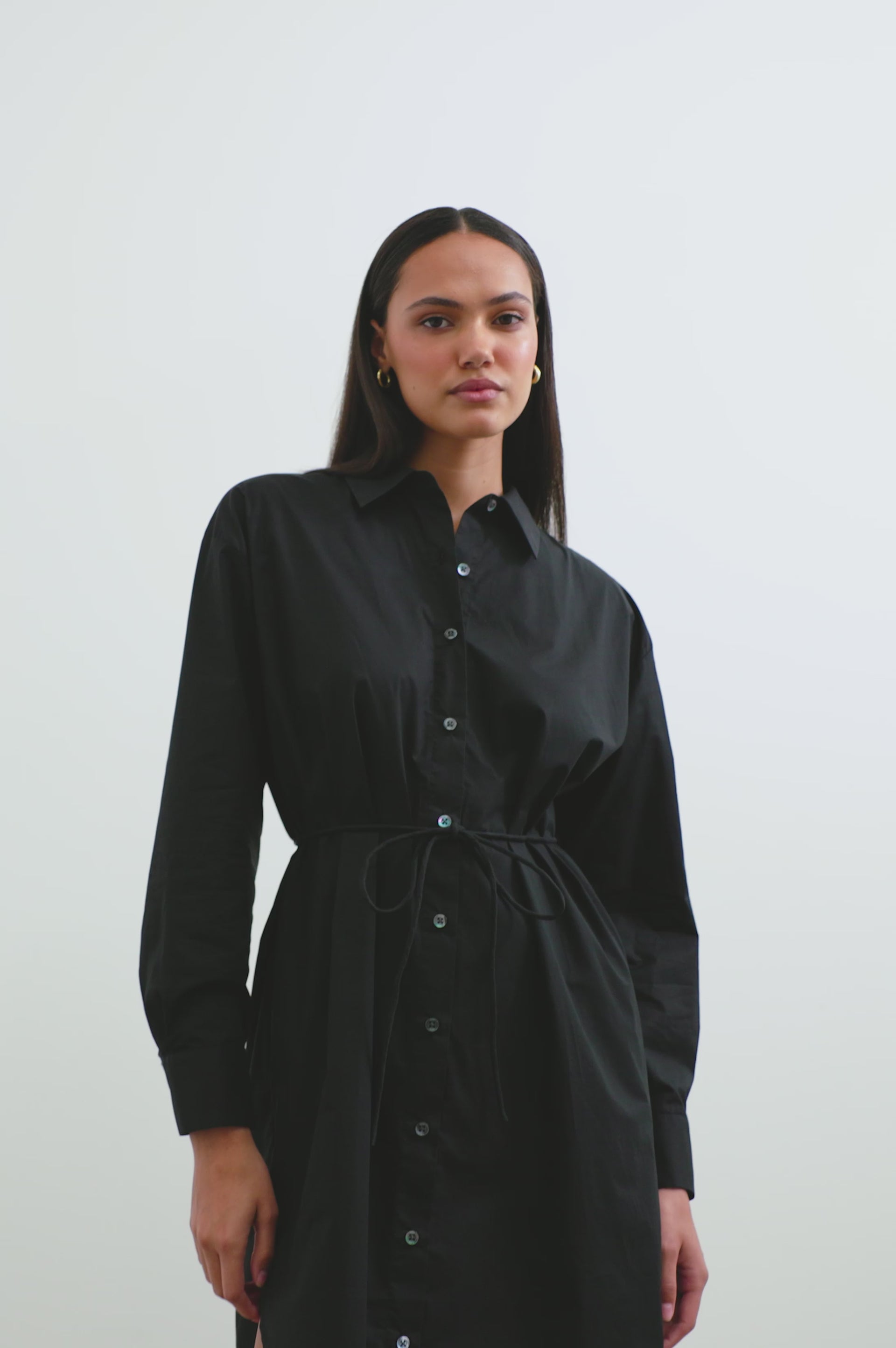 (Video): Black Harmony sleeveless midi dress shown on a model to showcase the fit and flowing fabric. Full body view of model with close up views. 