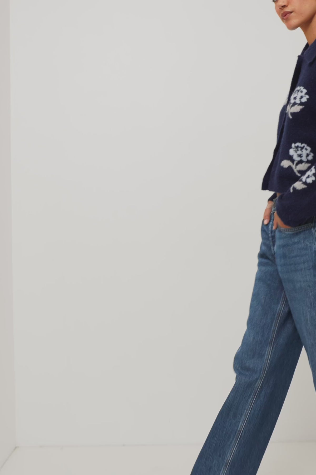 Amber Cardigan in Floral Jacquard Knit With Front Buttons, Point Collar, and Long Sleeves in Navy Petals Colorway - Upper Body Crop View Featured on Model Moving (Video).