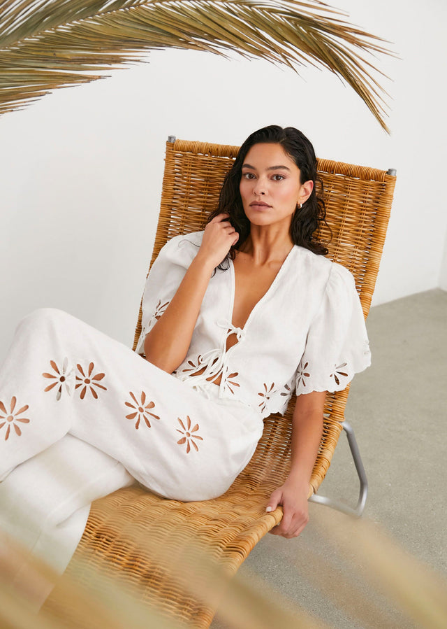 EDITORIAL IMAGE OF MODEL SITTING WEARING PARI TOP AND EMMIE PANT