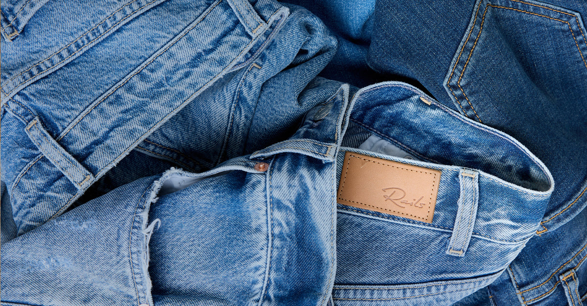 Stack of blue jeans with a visible brand label.