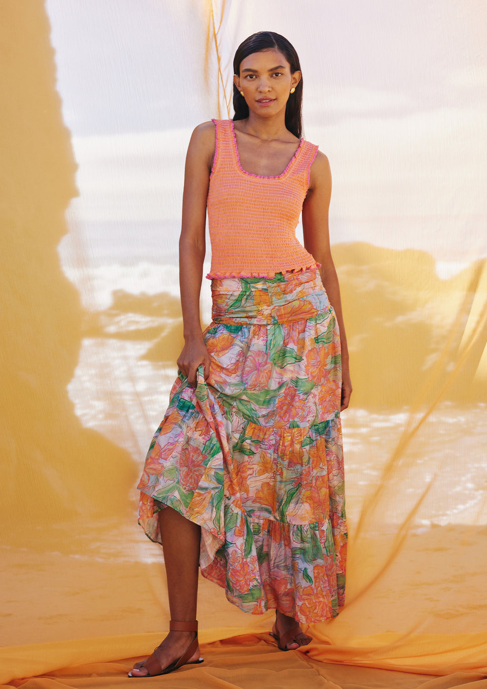 FRONT FULL BODY EDITORIAL IMAGE OF MODEL WEARING MAXINE TOP IN PAPAYA AND AGATHA SKIRT IN TROPICS