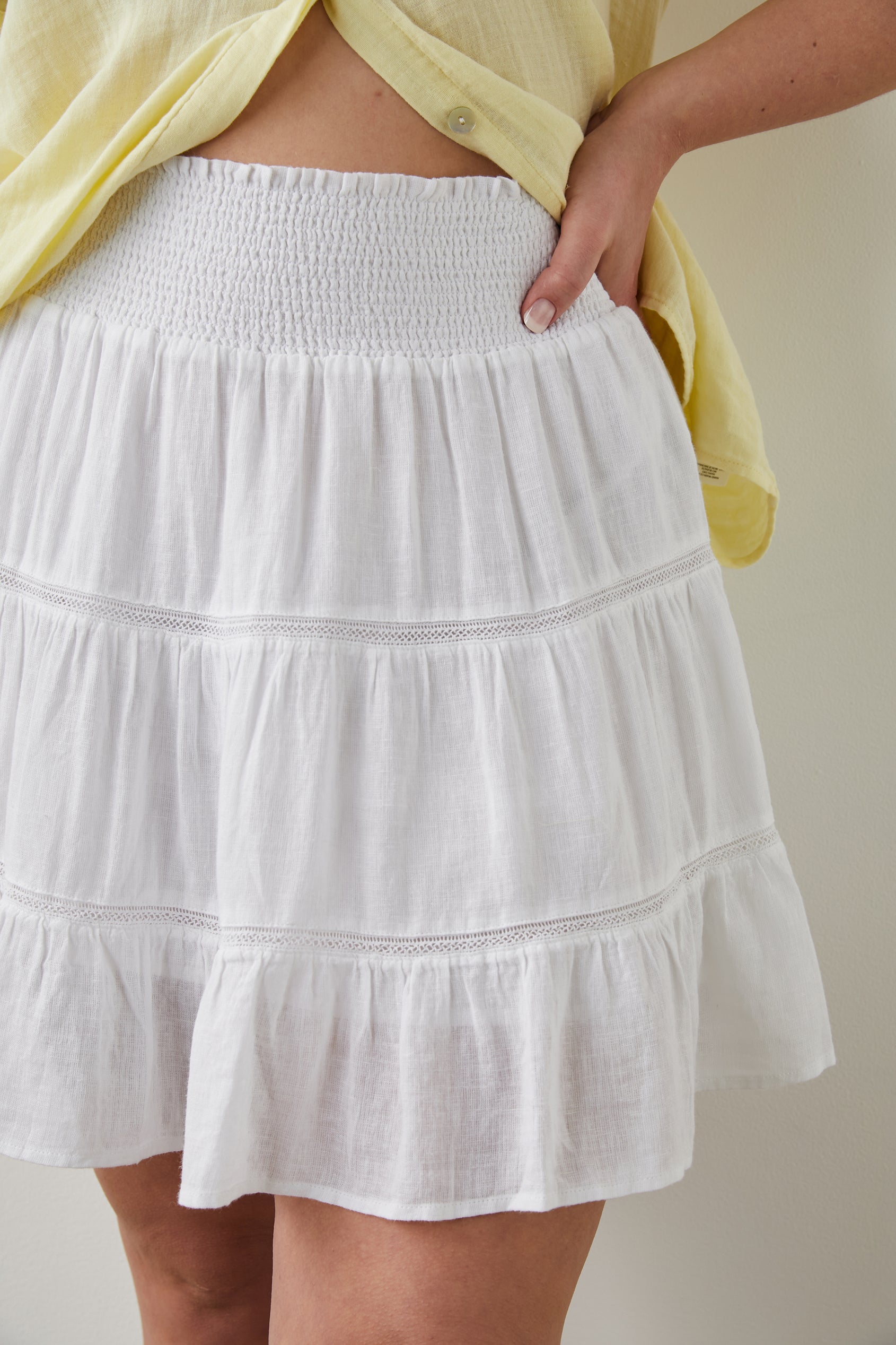Addison Mini Skirt with a Smocked Waist and Two Rows of Lace in White Lace Detail Colorway - Front View Featured on Model