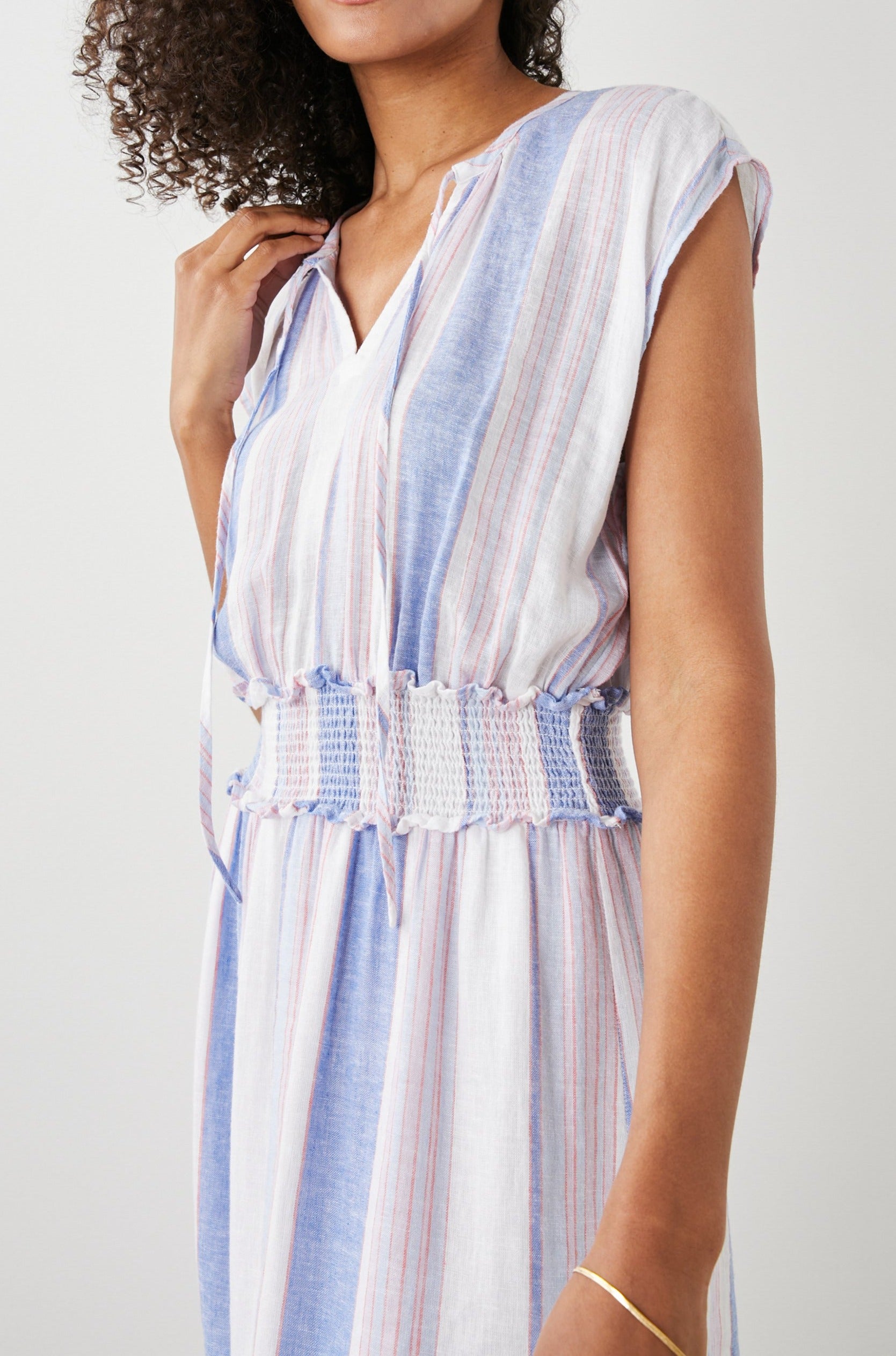 Ashlyn Short Sleeve Midi Dress with a V neck with Ties, a Smocked Waist and a Ruffle Tier at the Hem in Marini Stripe Colorway, Vertical Stripes in Pink and Blue on White - Front View Featured on Model