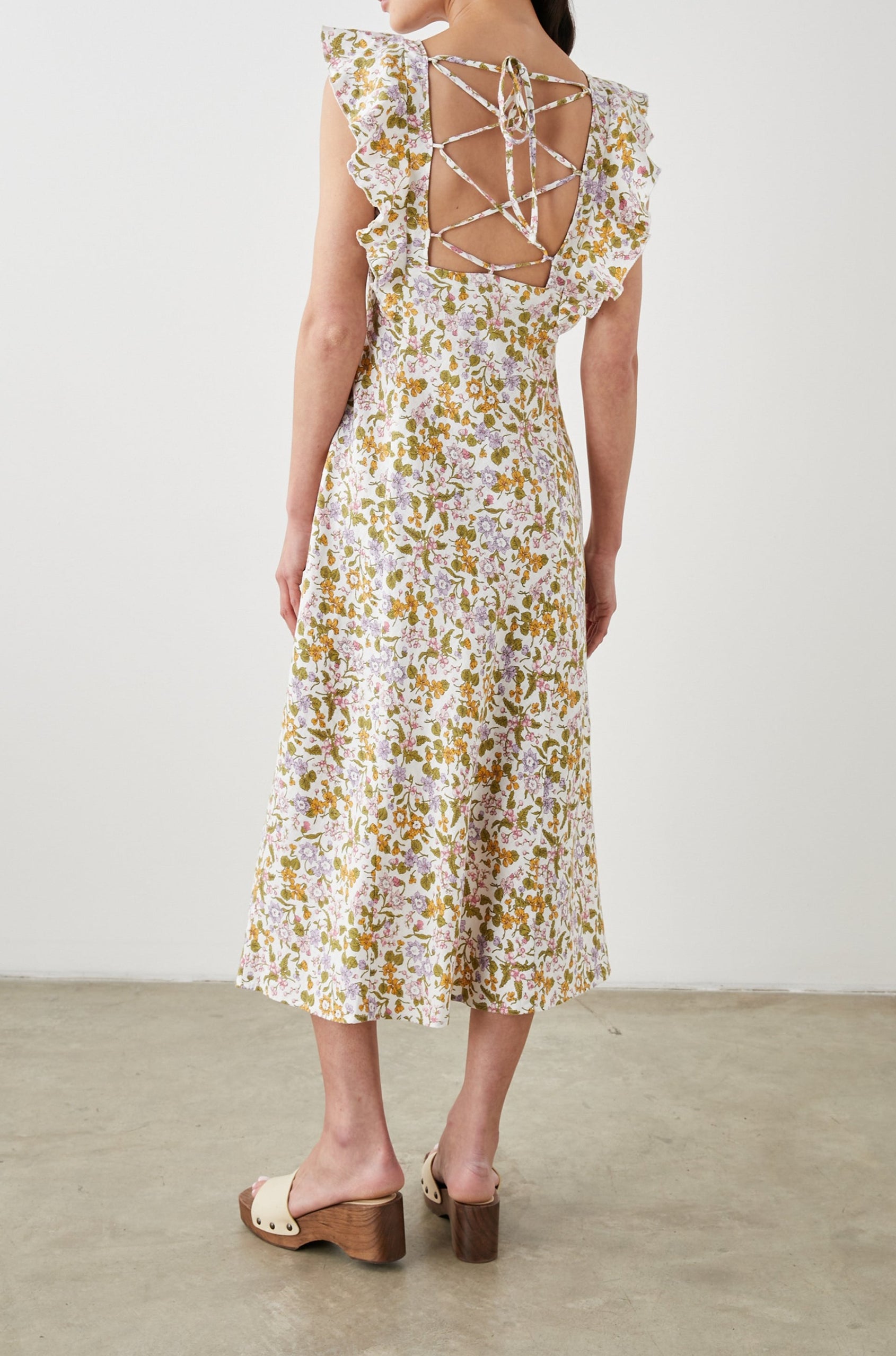 Constance Short Sleeve Midi Dress with Flutter Sleeves, a V Neck, and Cross Ties Across the Mid to Upper Back in Tansy Colorway, Brown, Orange, Purple, Pink and Green on White - Back Full Body View Featured on Model 