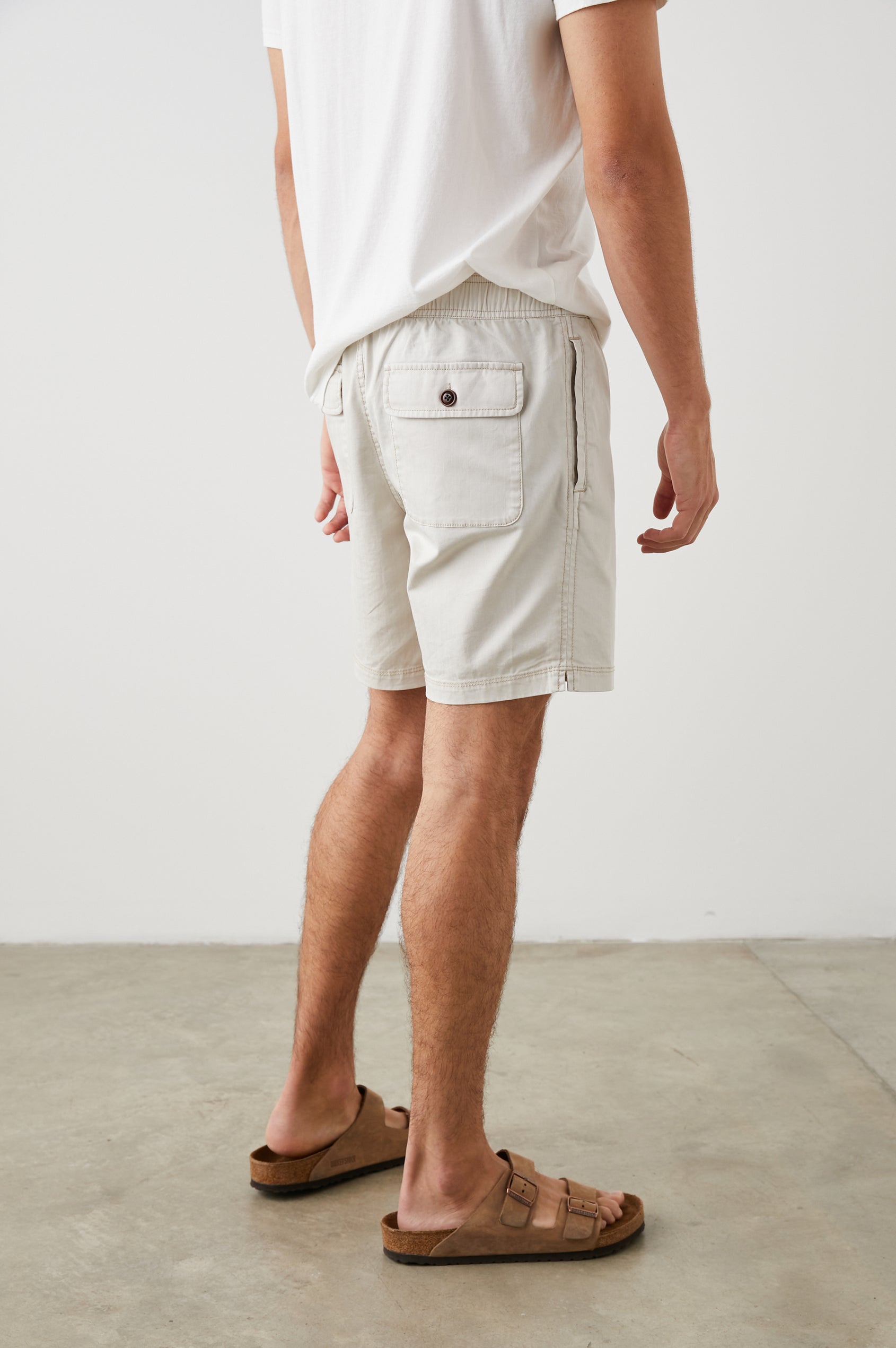 Cruz Shorts with a Drawstring Waist, Two Front Pockets, Two Back Button Flap Pockets in Natural Colorway - Side View Featured on Model 