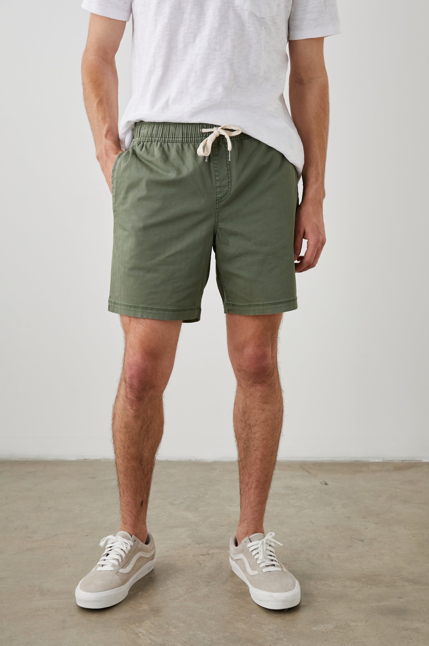 Cruz Shorts with a Drawstring Waist, Two Front Pockets, Two Back Button Flap Pockets in Spring Olive Colorway - Front View Featured on Model 