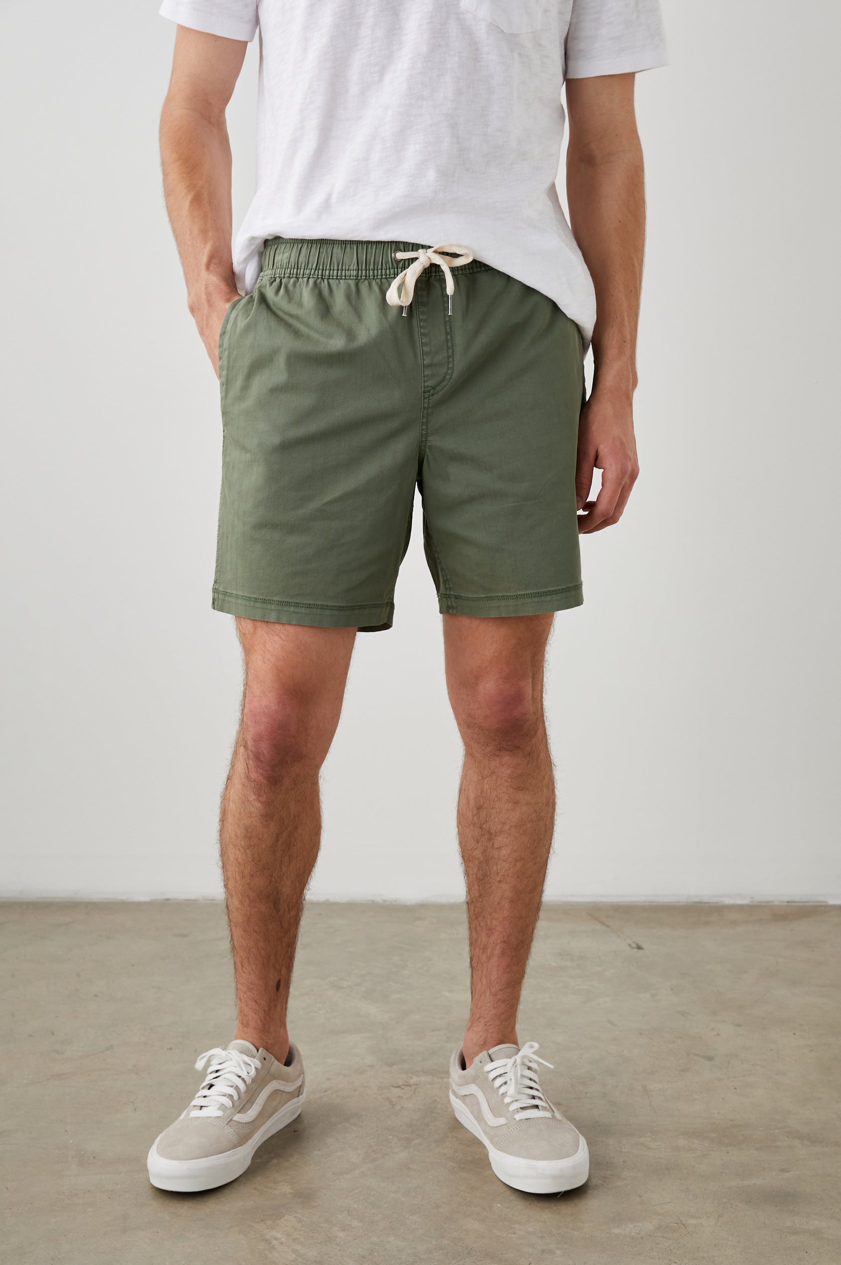 Cruz Shorts with a Drawstring Waist, Two Front Pockets, Two Back Button Flap Pockets in Spring Olive Colorway - Front View Featured on Model 