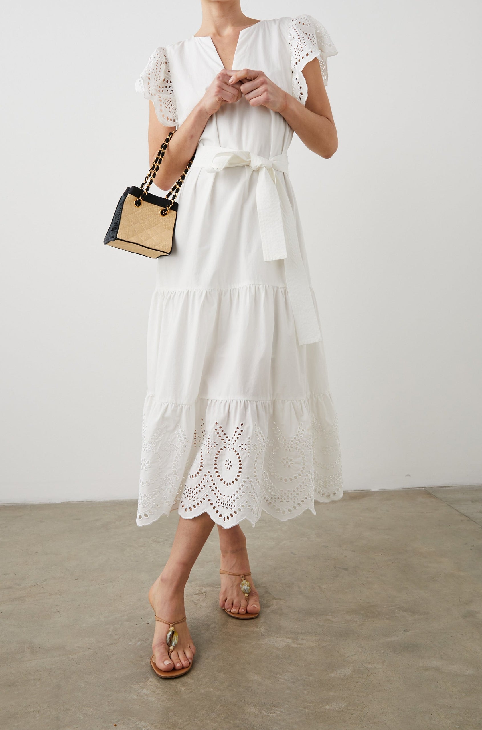 Gia Short-Sleeve Midi Dress with Flutter Sleeves, a V Neck, a Fabric Tie at the Waist, a Tiered Skirt and Eyelet Detail on the Sleeves and Hem in White Colorway - Front Full Body View Featured on Model