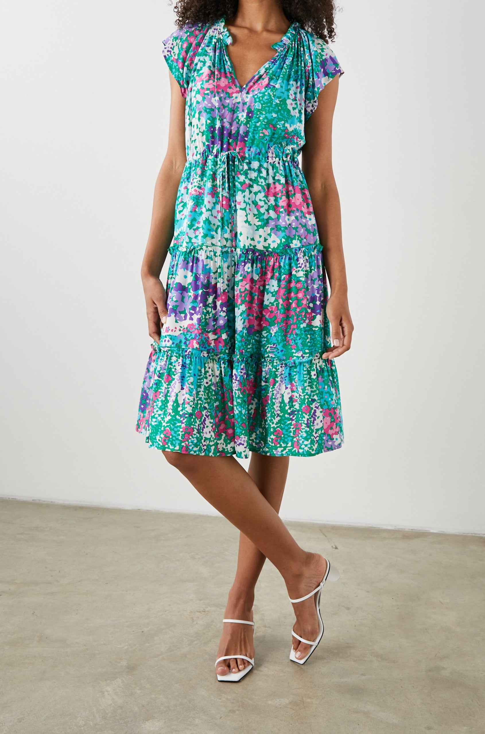 Juni Short Sleeve Midi Dress with a V Neck, Light Ruching along the Neckline, a Drawstring Waist, and a Tiered Skirt in Gardenia Floral Colorway, in Greens, Blues, Purples, Pinks and White - Front Full Body View Featured on Model