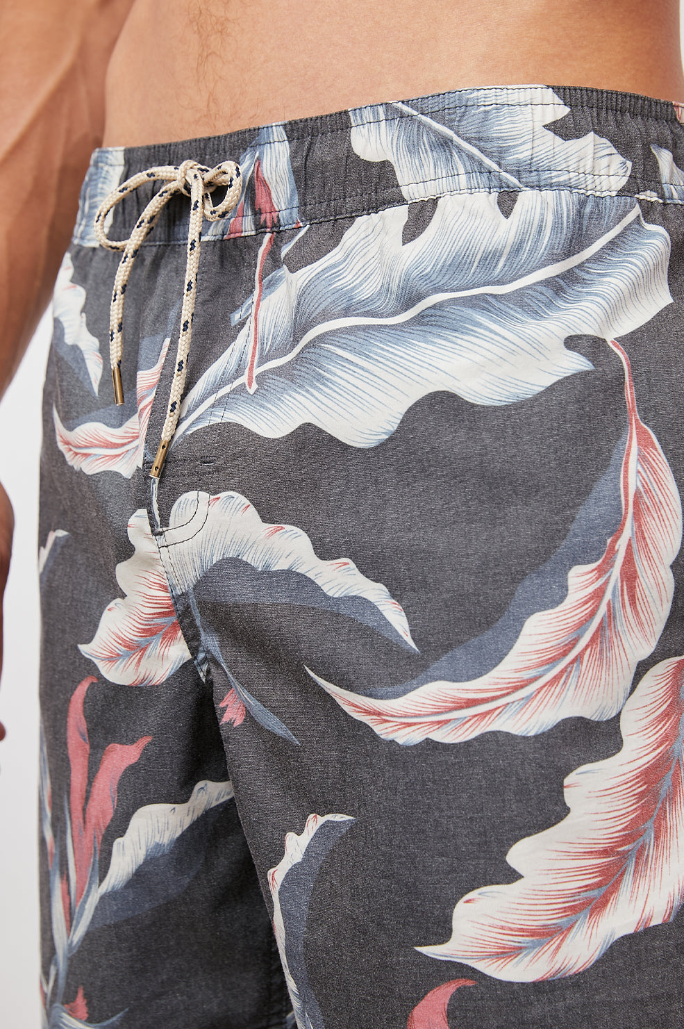 Kian Swim Shorts with an Elastic Drawstring Waistband, Two Front Pockets and a Back Button Flap Pocket in Paradise Nights Colorway, a Floral Print in Pinks, Blues and White on Black - Front View Featured on Model