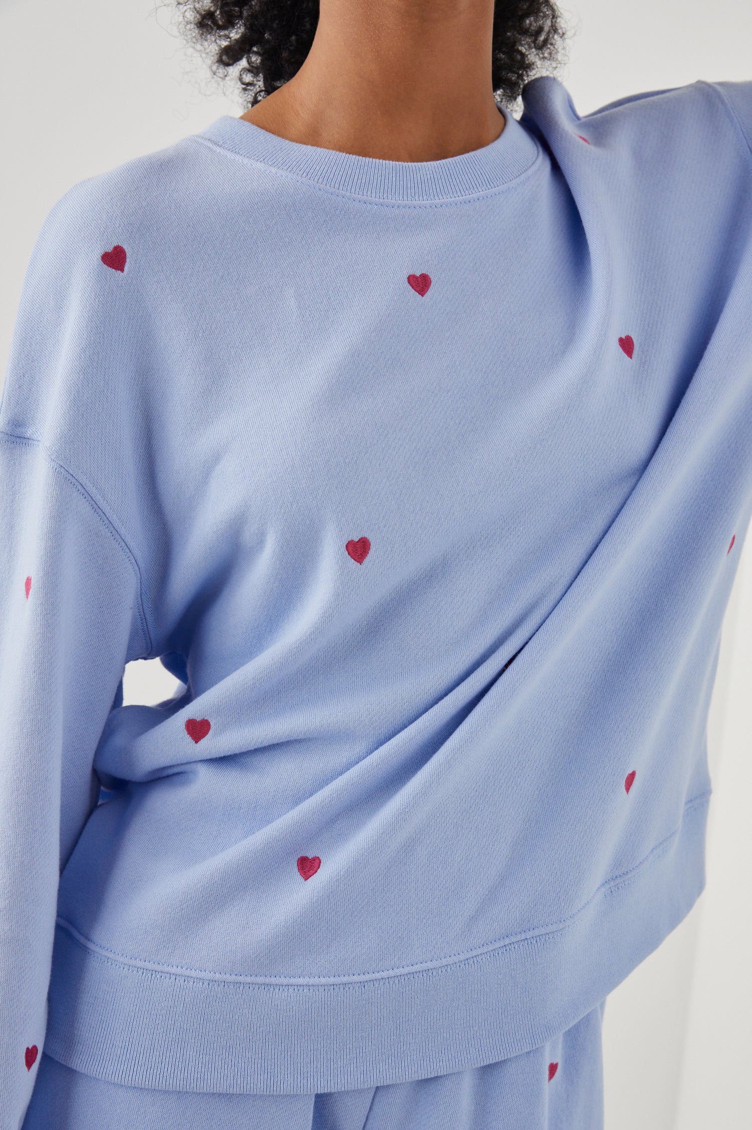Ramona Long-Sleeve Sweatshirt with a Crew Neck in Pink Heart Embroidery Colorway, Pink Hearts on Blue - Front View Featured on Model