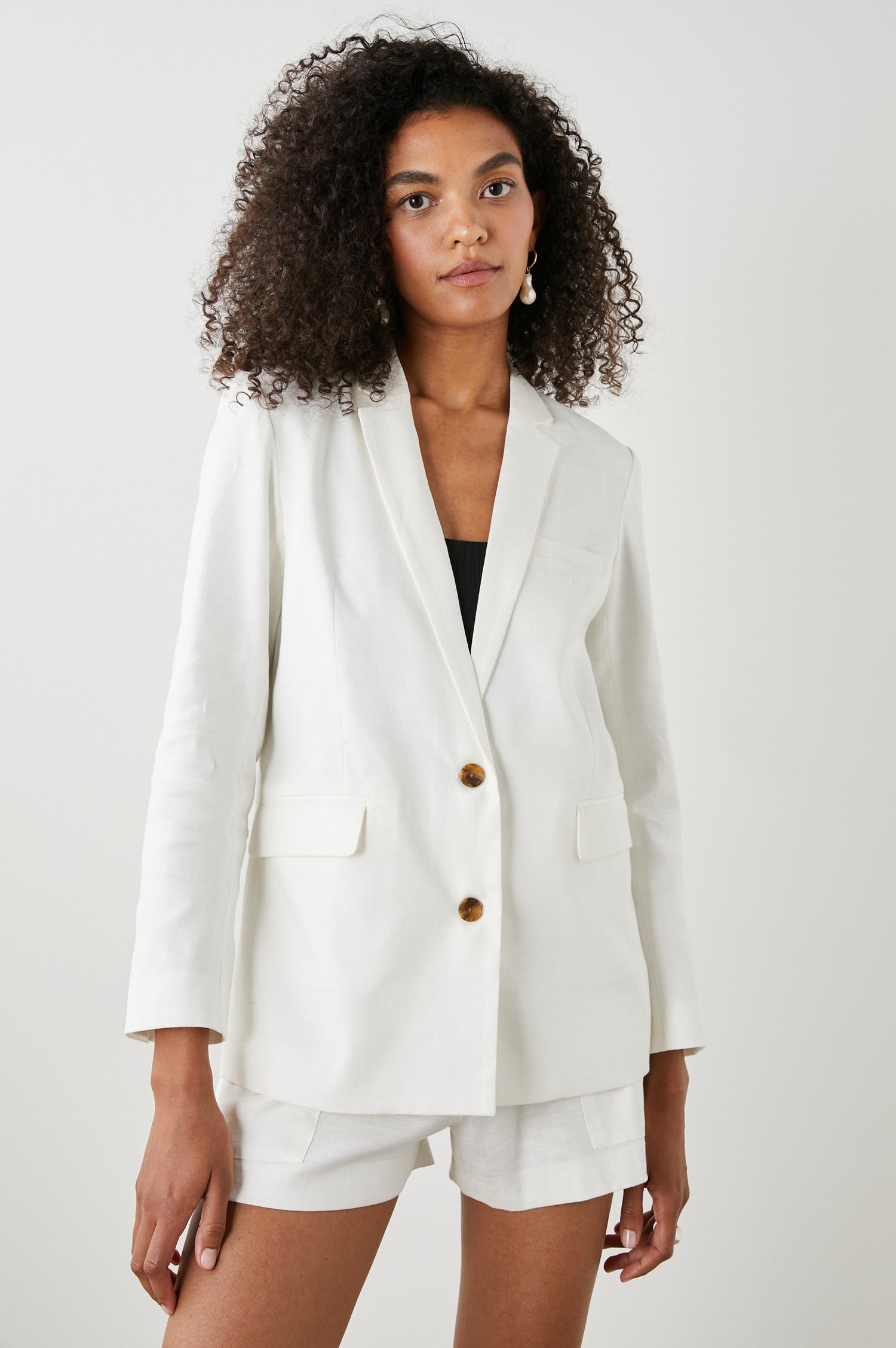 Stanton Blazer with Two Button Closure, Two Front Flap Pockets, a Chest Patch Pocket and Four-Button Cuffs in Creme Colorway - Front View Featured on Model