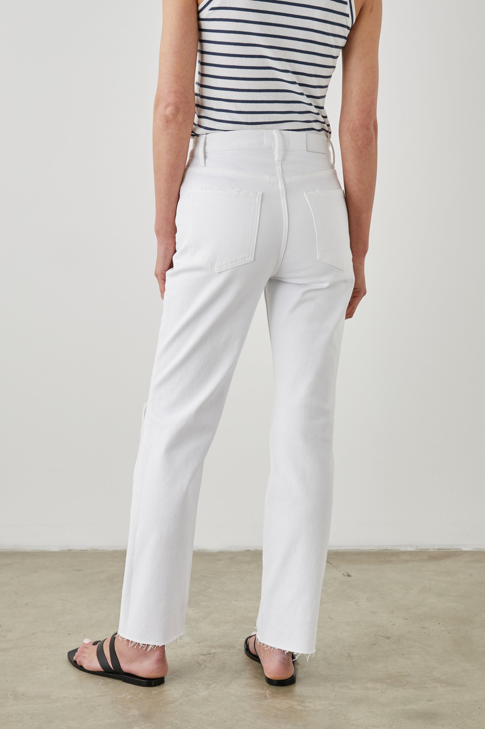 Topanga Straight Jeans with a Hole at the Knee and Fraying, Belt Loops, Two Front Pockets plus a Coin Pocket and Two Back Patch Pockets in Salt White Distress Colorway - Back View Featured on Model